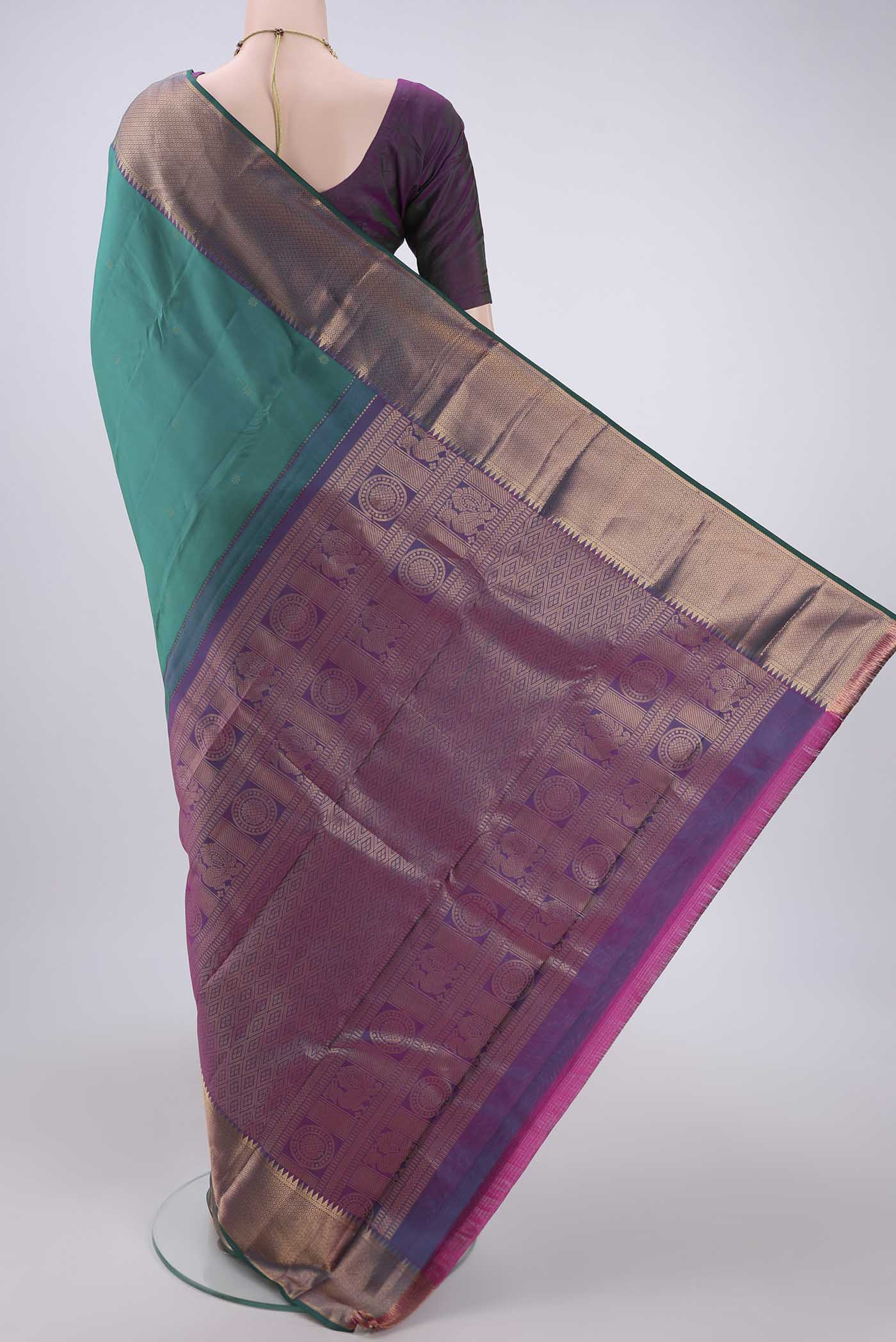Flat view of Green Kanchipuram Silk Saree with Zari Butta on the body and Zari Border. 