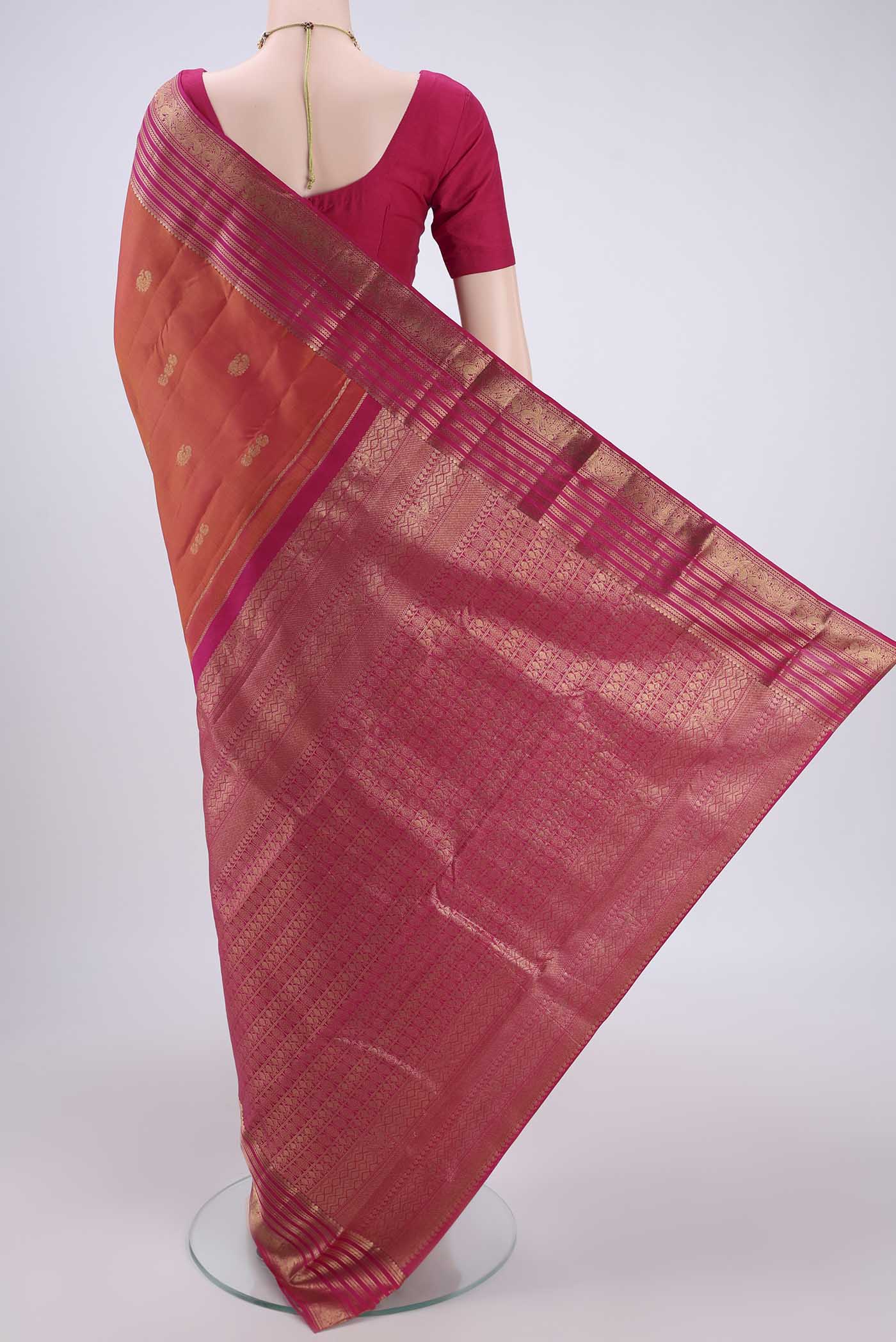 Flat view of Brick Orange Kanchipuram Silk Saree with Zari Butta on the body and Zari Border. 