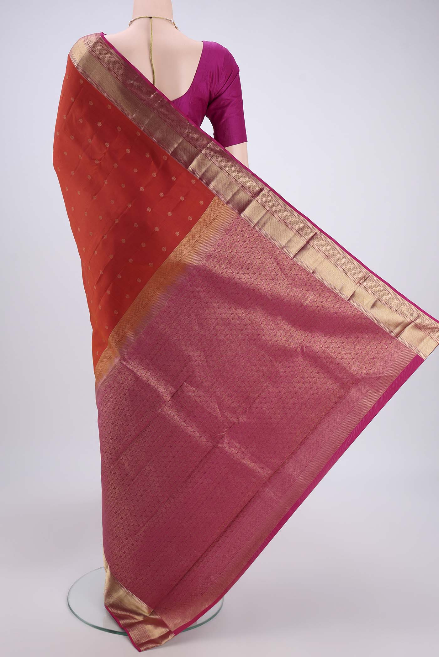 Flat view of Orange Kanchipuram Silk Saree with Zari Butta on the body and Zari Border. 