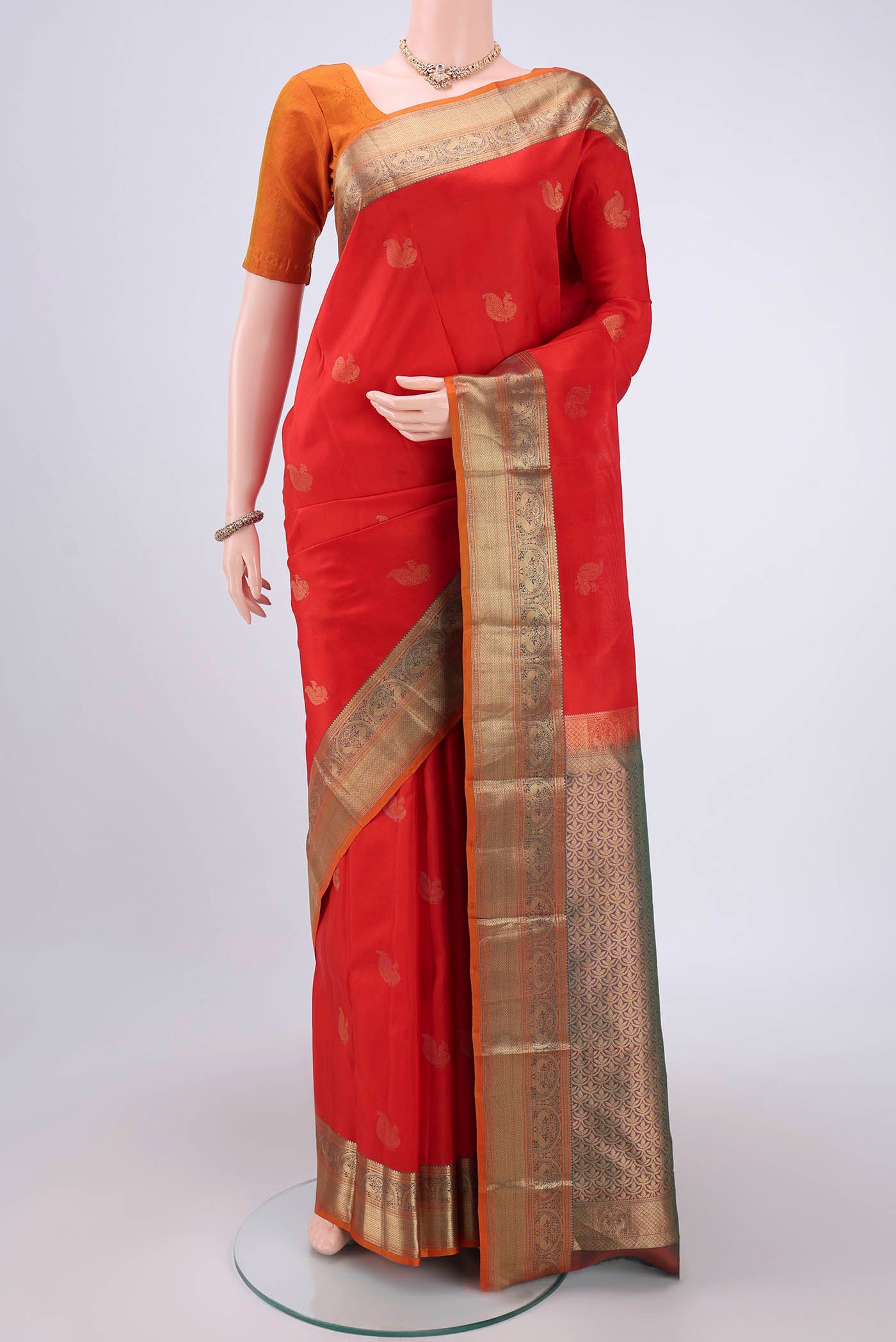 Red Kanchipuram Silk Saree with Zari Butta on the body and Zari Border.  displayed on a mannequin