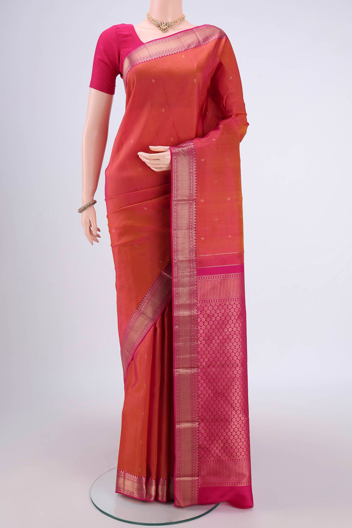 Pinkish Yellow Kanchipuram Silk Saree with Zari Butta on the body and Zari Border.  displayed on a mannequin