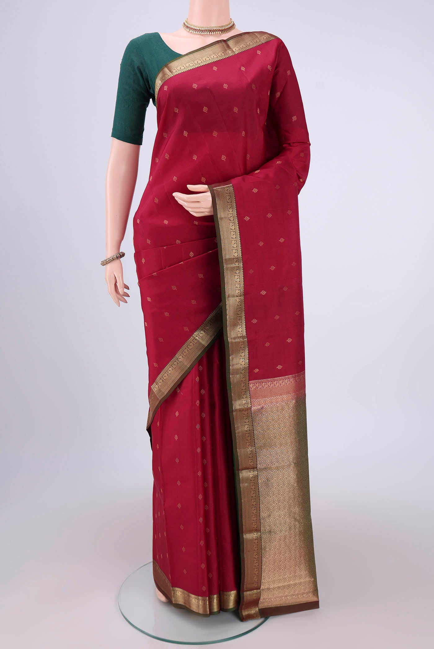 Maroon Kanchipuram Silk Saree with Zari Butta on the body and Zari Border.  displayed on a mannequin