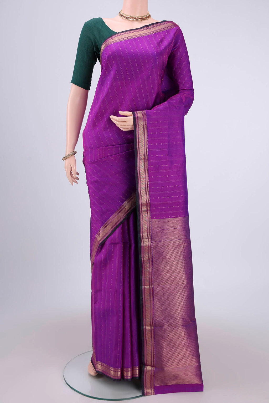 Magenta Kanchipuram Silk Saree with Zari Butta on the body and Zari Border.  displayed on a mannequin