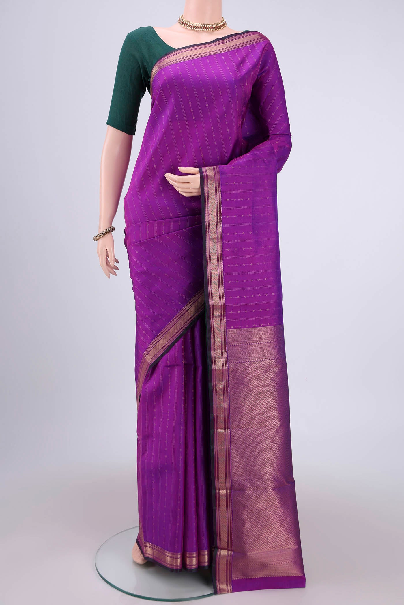 Magenta Kanchipuram Silk Saree with Zari Butta on the body and Zari Border.  displayed on a mannequin