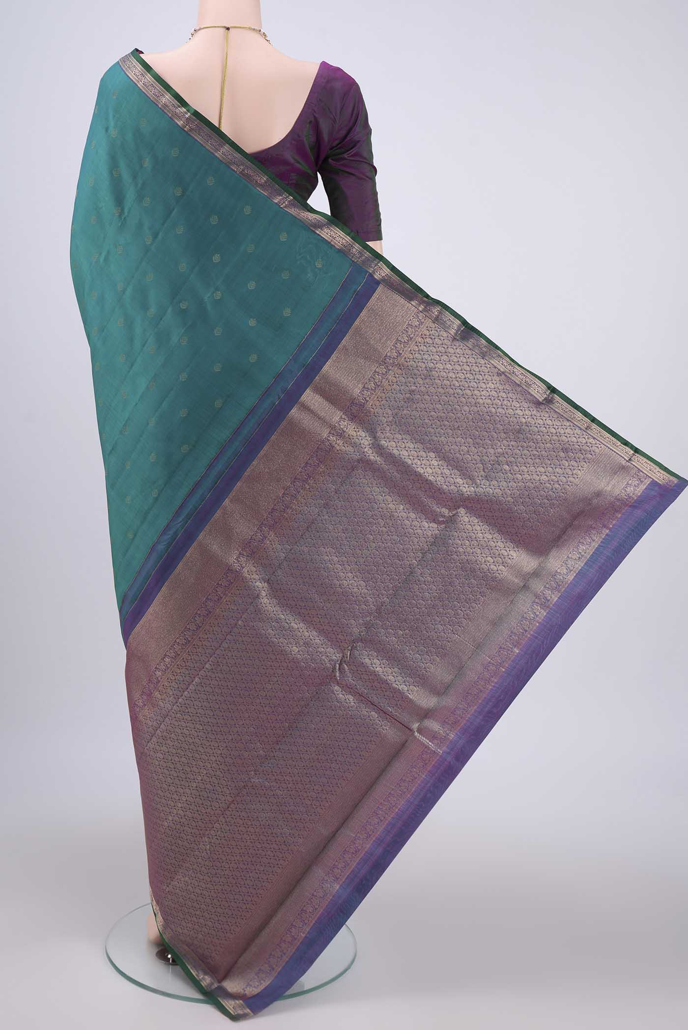 Flat view of Green Kanchipuram Silk Saree with Zari Butta on the body and Zari Border. 