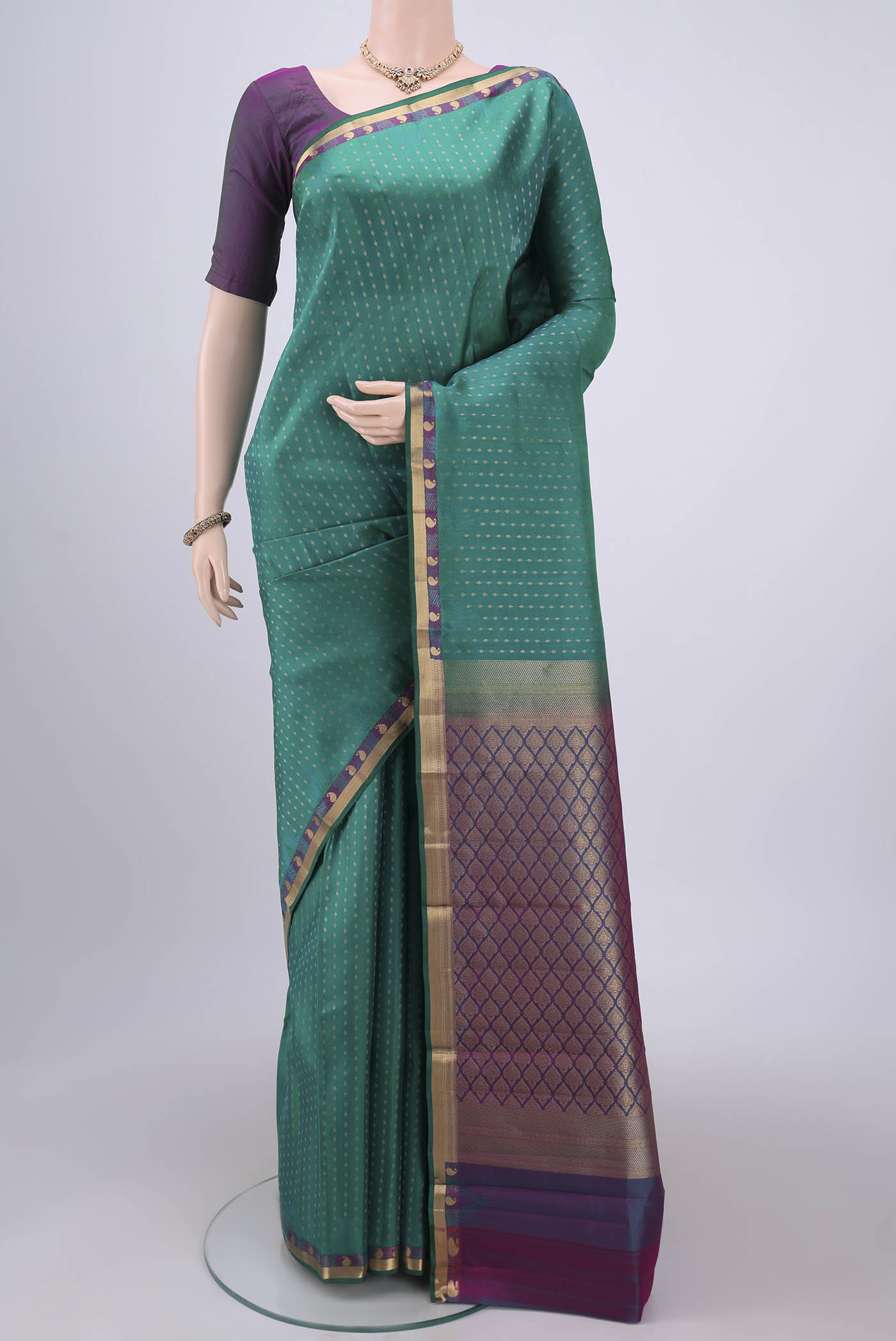 Green Kanchipuram Silk Saree with Zari Butta on the body and Zari Border.  displayed on a mannequin