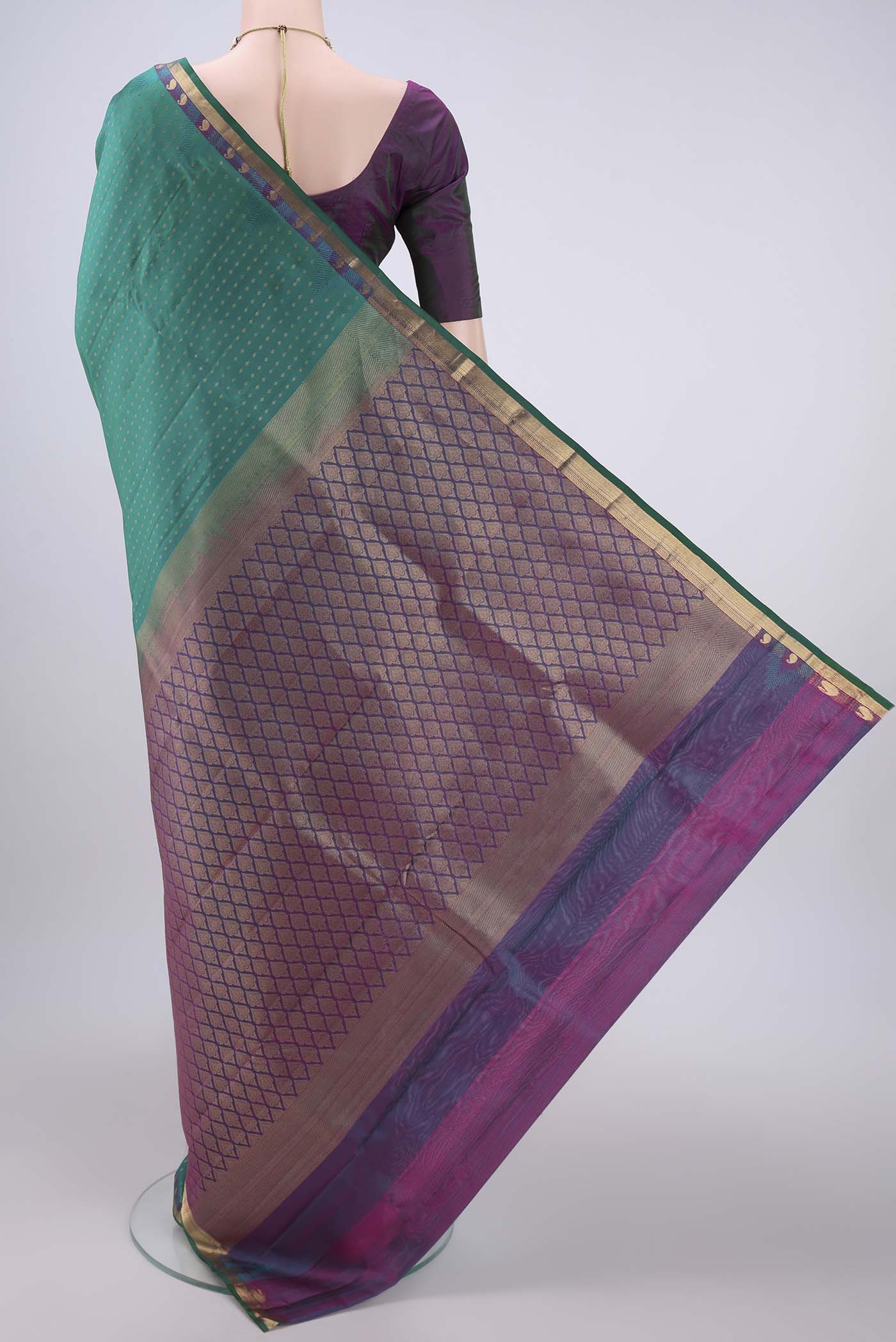 Flat view of Green Kanchipuram Silk Saree with Zari Butta on the body and Zari Border. 