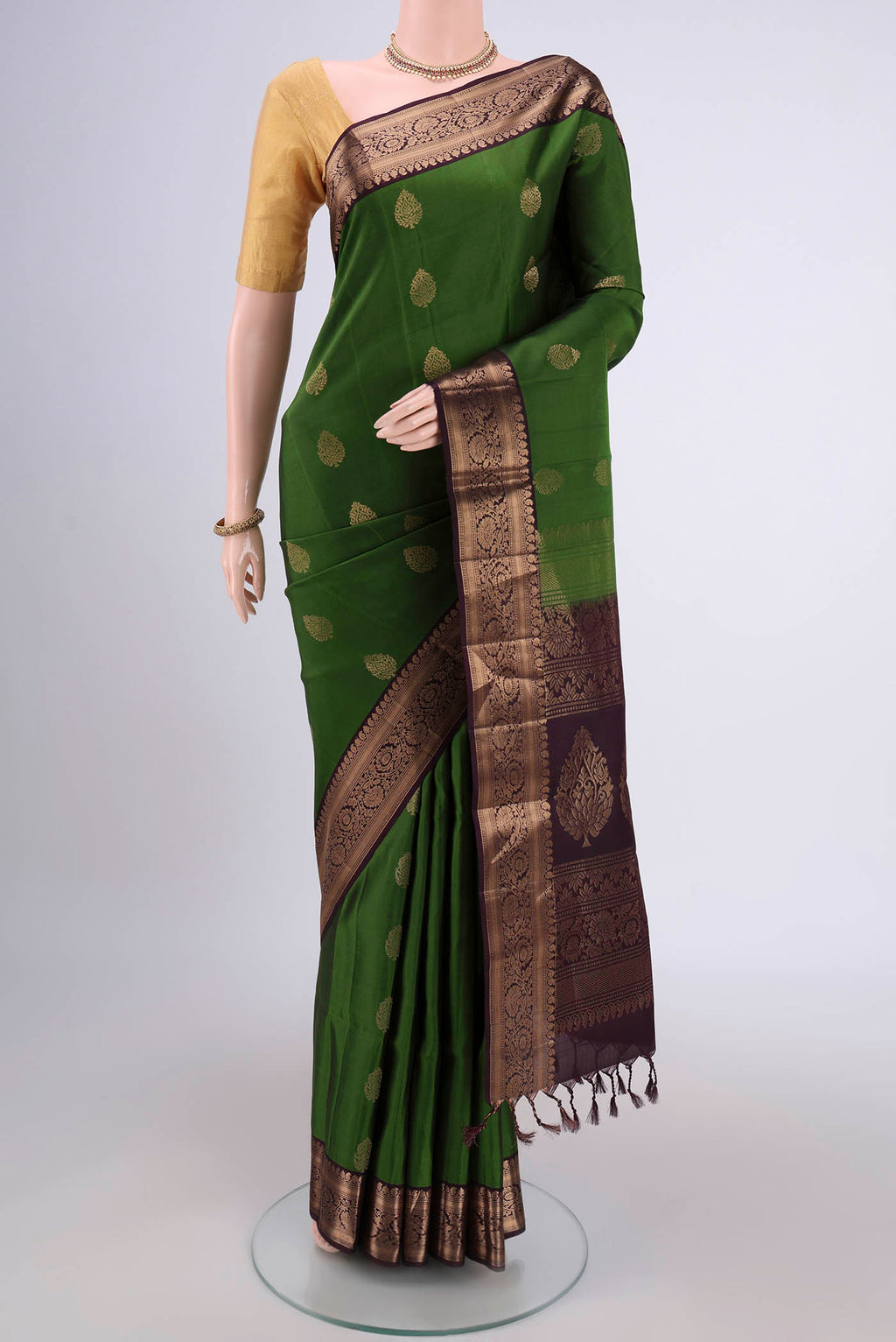 Green Soft Silk Saree with Zari Butta on the body and Zari Border.  displayed on a mannequin
