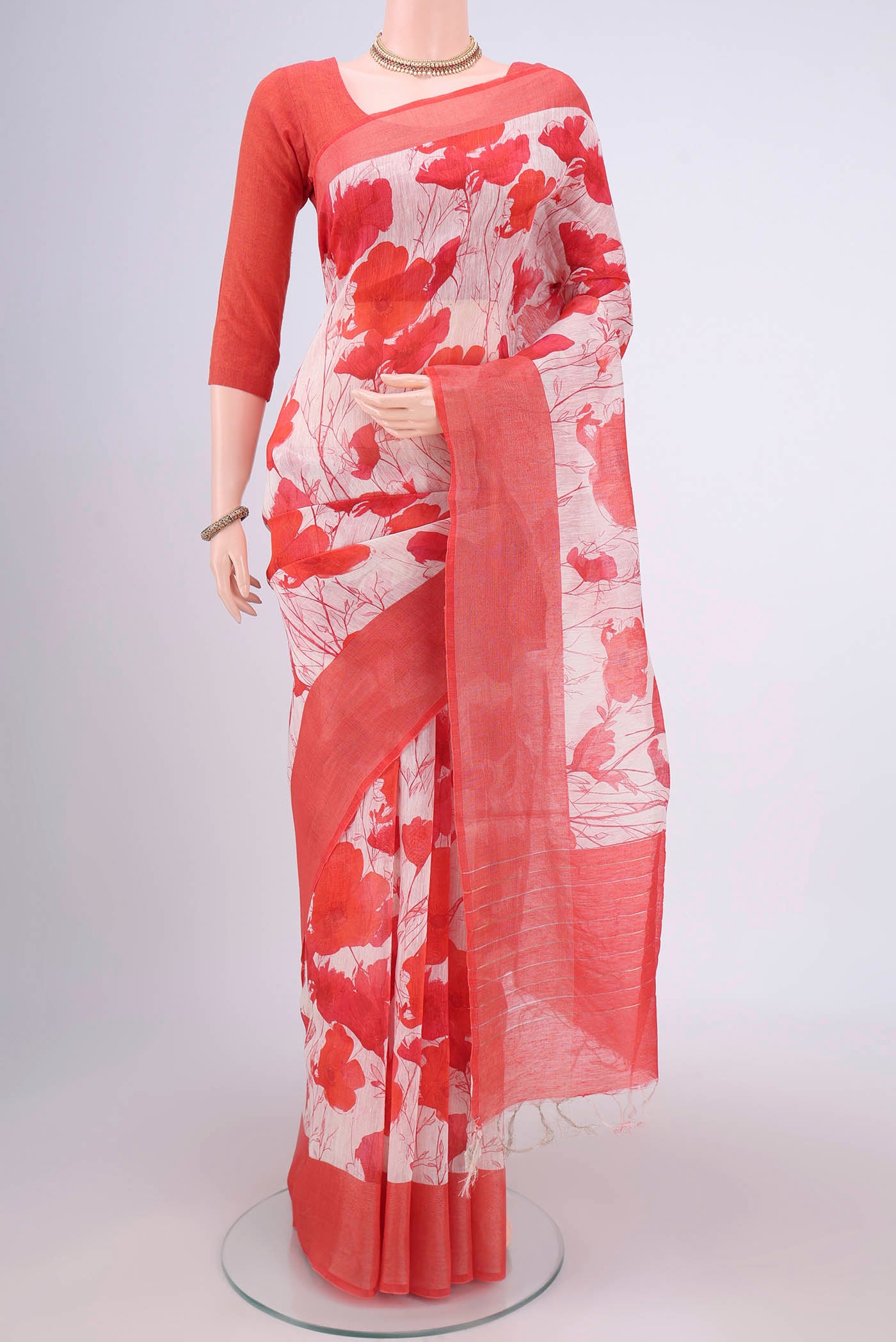 Off White Linen Saree with Floral Print on the body and Zari Border.  displayed on a mannequin