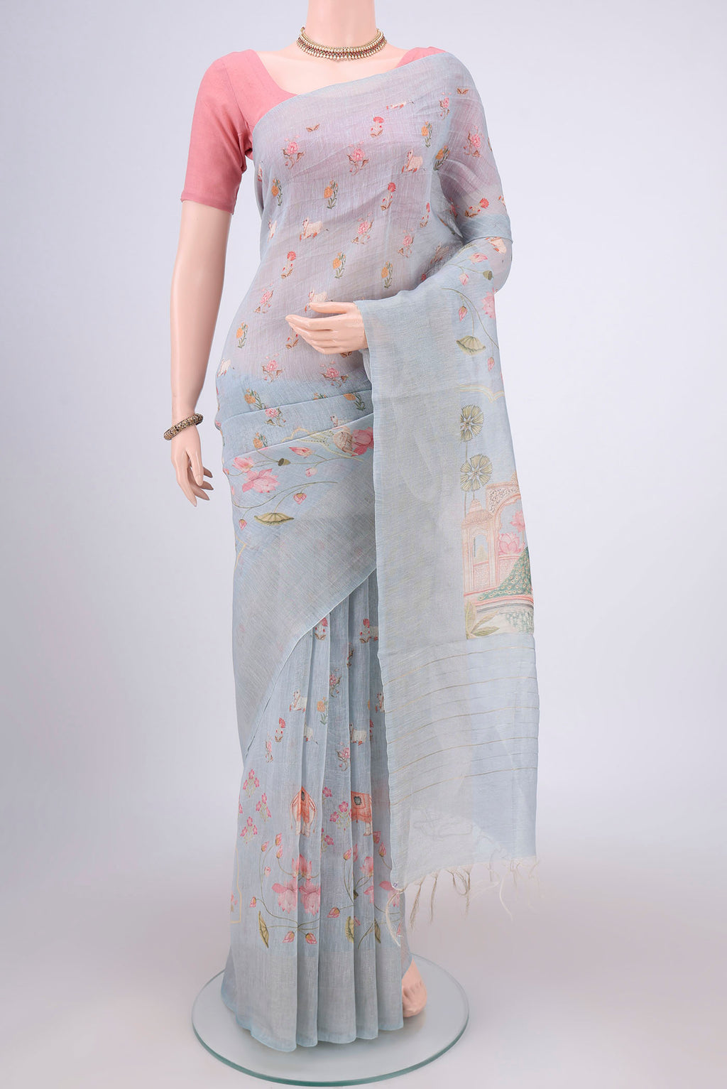 Blue Grey Linen Saree with Floral Print on the body and Zari Border.  displayed on a mannequin