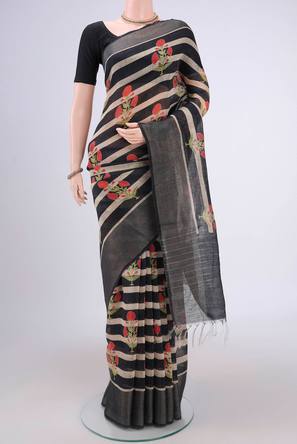 Black Linen Saree with Floral Print on the body and Zari Border.  displayed on a mannequin