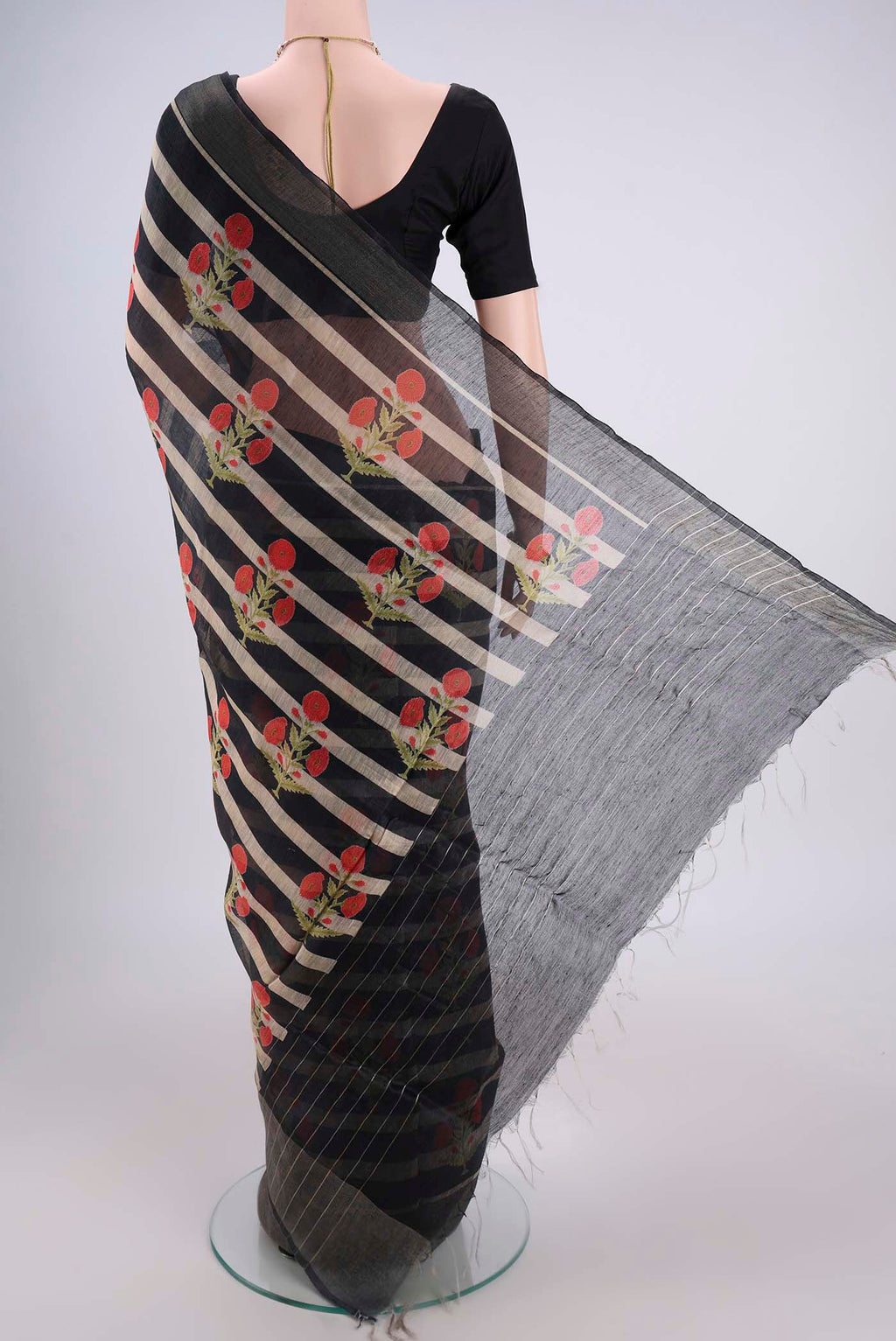 Flat view of Black Linen Saree with Floral Print on the body and Zari Border. 