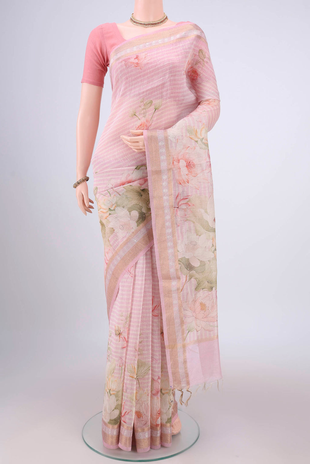 Off White Linen Saree with Floral Print on the body and Zari Border.  displayed on a mannequin