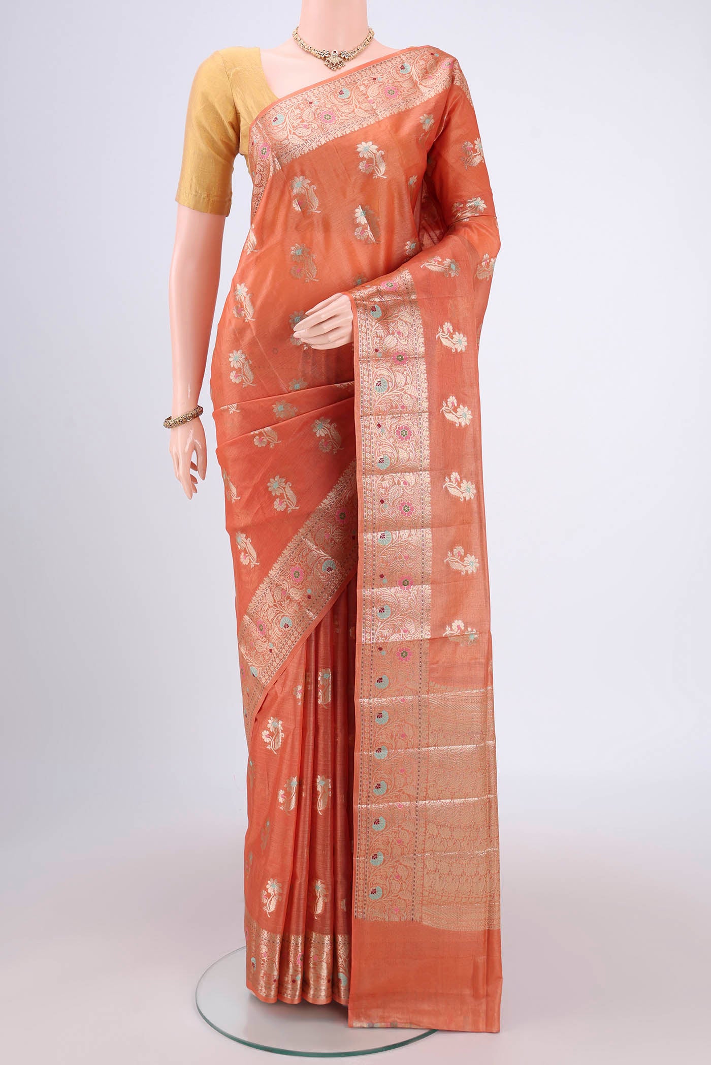Brick Orange Banarasi Tussar Silk Saree with Zari And Thread Butta on the body and Zari And Thread Border.  displayed on a mannequin