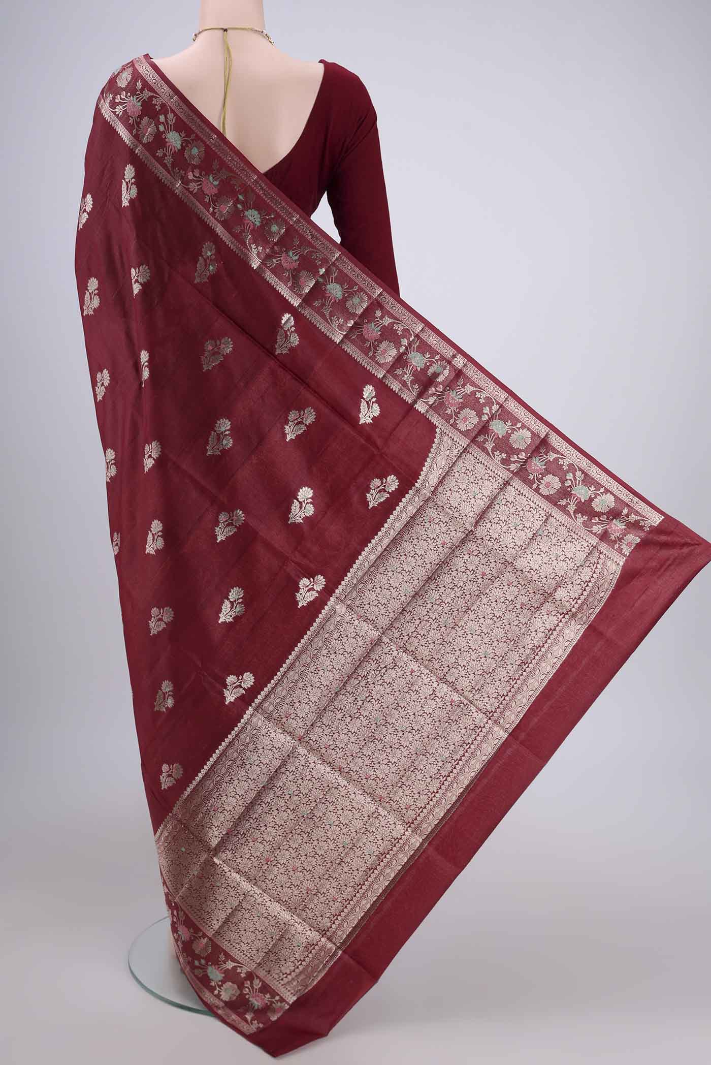 Flat view of Maroon Banarasi Tussar Silk Saree with Zari Butta on the body and Zari And Thread Border. 