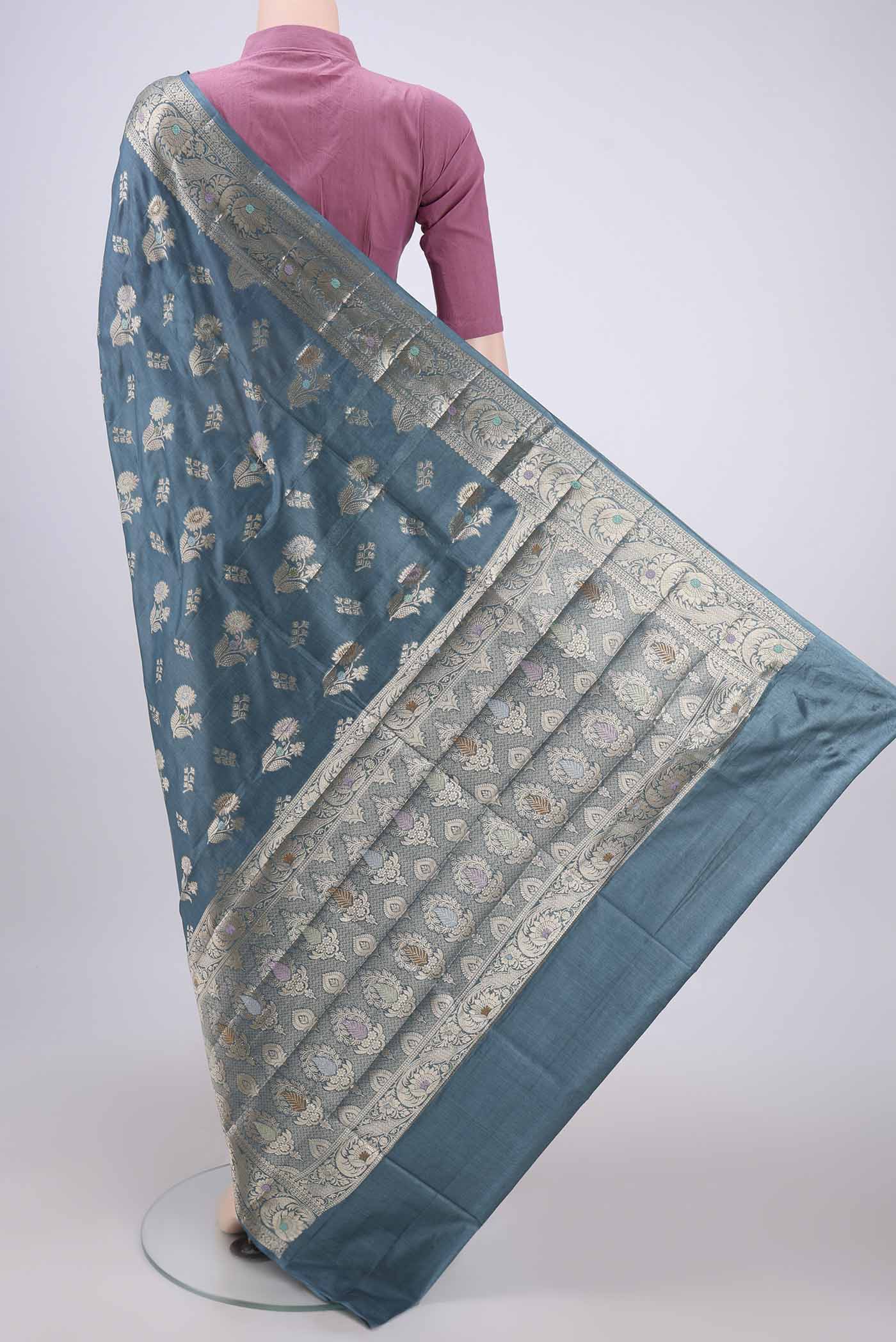 Flat view of Maya Blue Banarasi Tussar Silk Saree with Zari And Thread Butta on the body and Zari And Thread Border. 