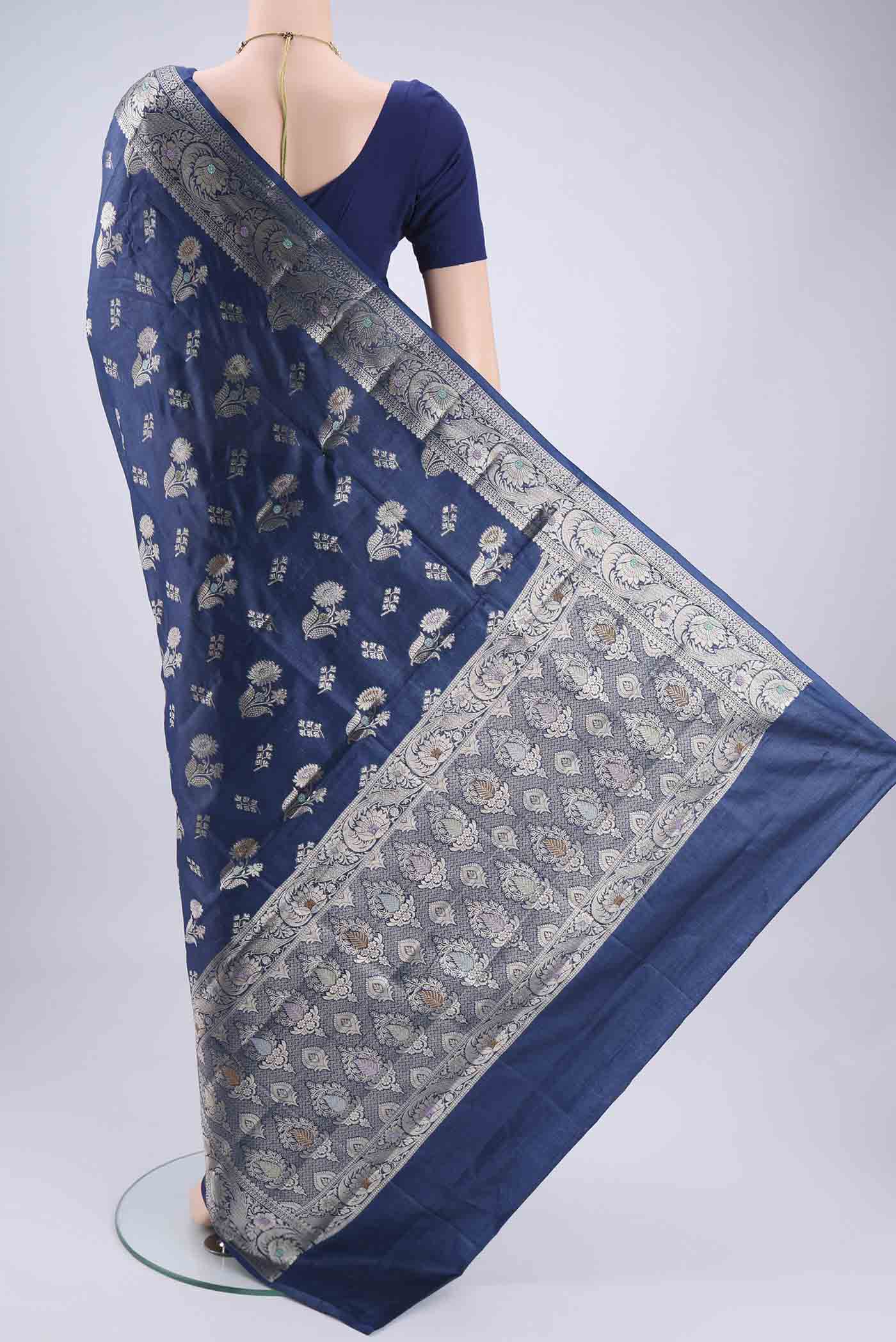 Flat view of Blue Banarasi Tussar Silk Saree with Zari And Thread Butta on the body and Zari And Thread Border. 