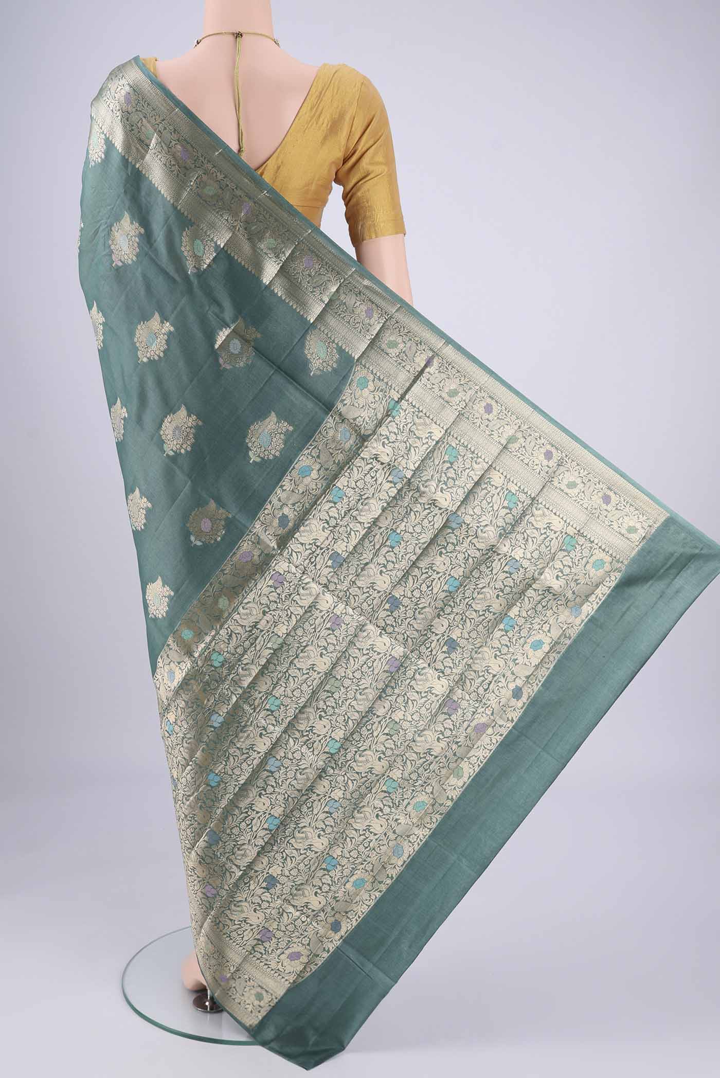 Flat view of Maya Blue Banarasi Tussar Silk Saree with Zari And Thread Butta on the body and Zari And Thread Border. 