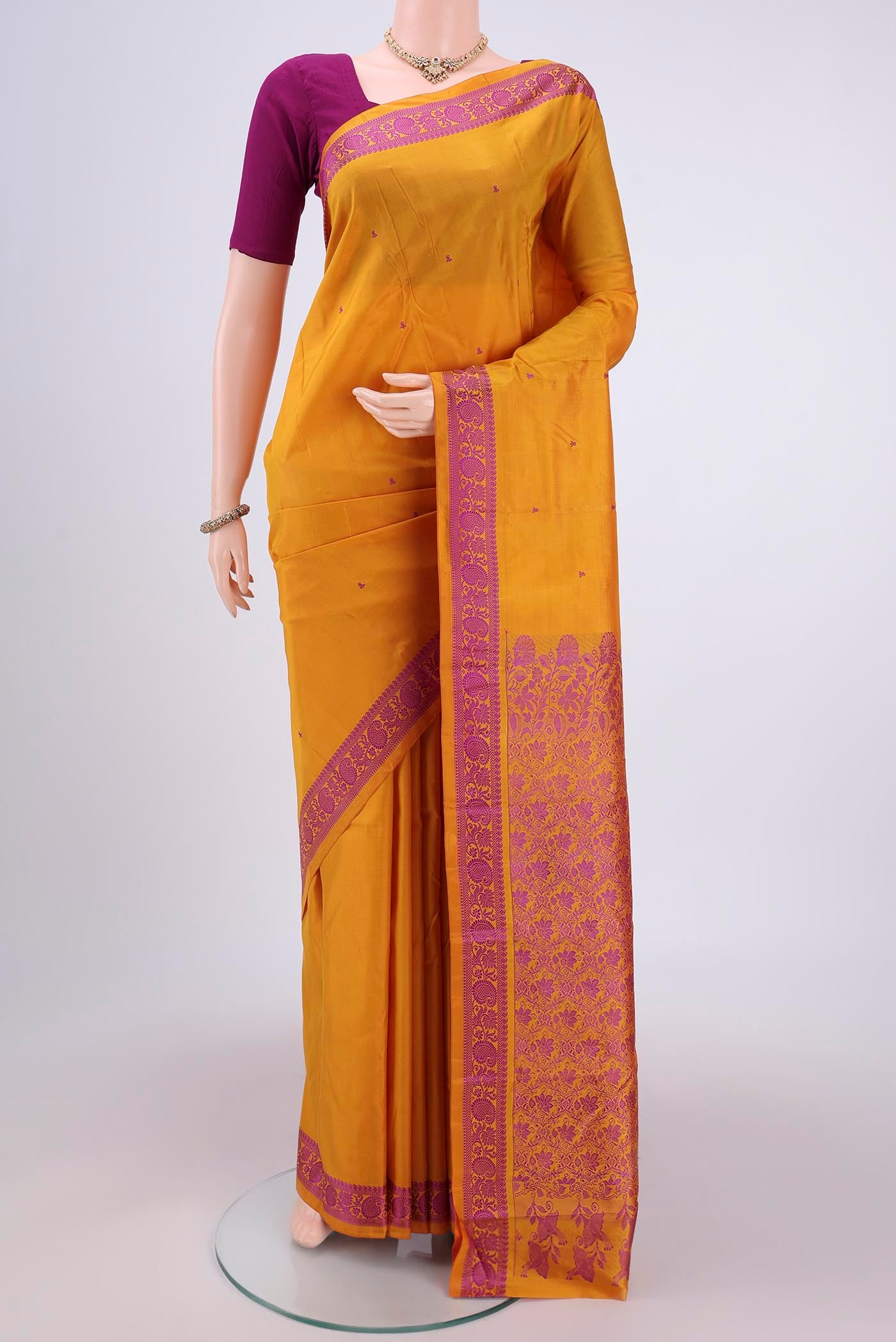 Mustard Kanchipuram Silk Saree with Thread Butta on the body and Thread Border.  displayed on a mannequin