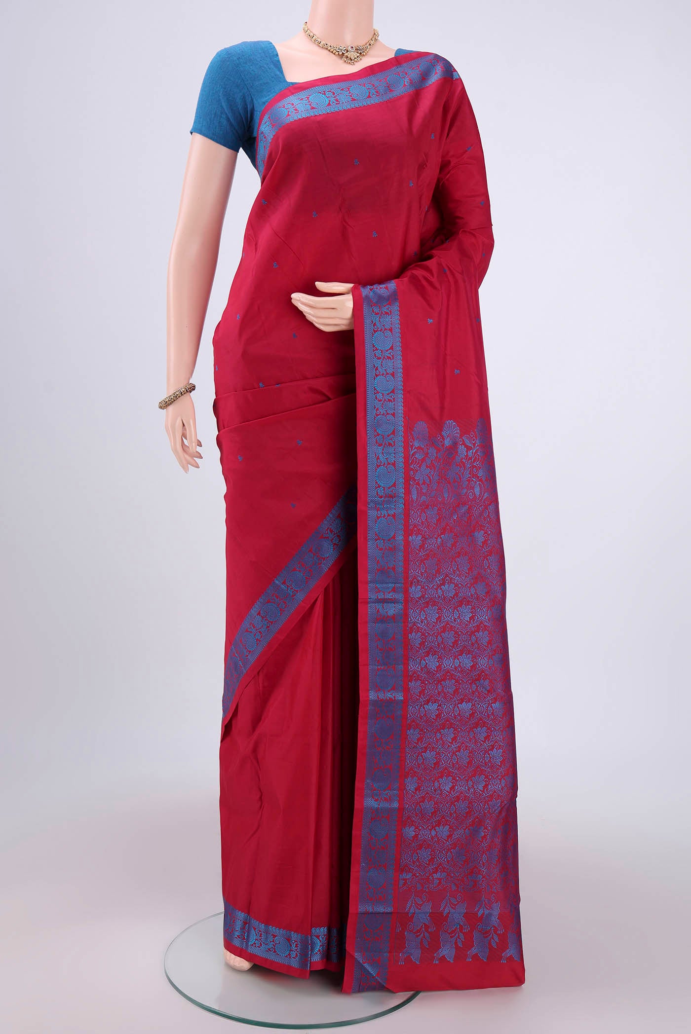 Maroon Kanchipuram Silk Saree with Thread Butta on the body and Thread Border.  displayed on a mannequin