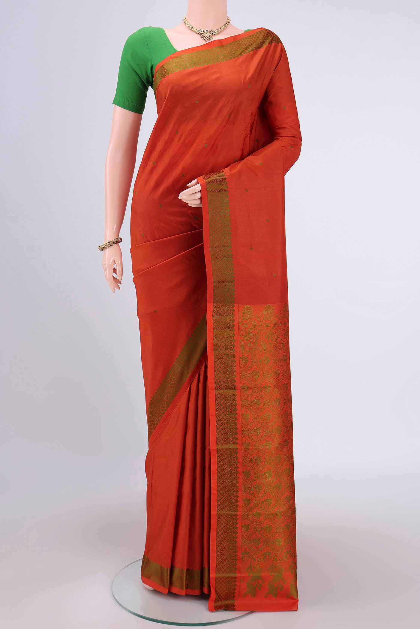 Rust Kanchipuram Silk Saree with Thread Butta on the body and Thread Border.  displayed on a mannequin