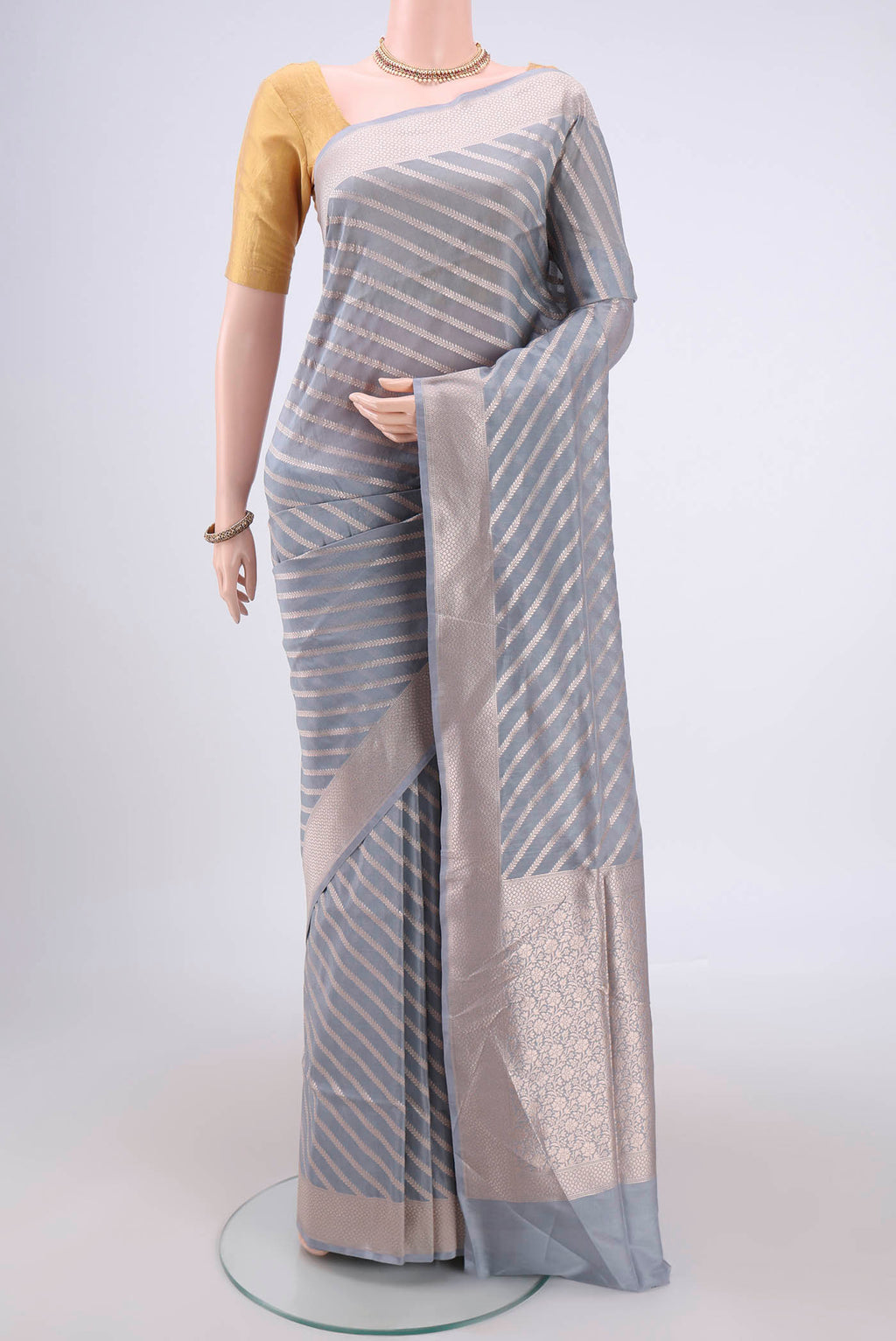Blue Grey Banarasi Silk Saree with Stripes on the body and Zari Border.  displayed on a mannequin
