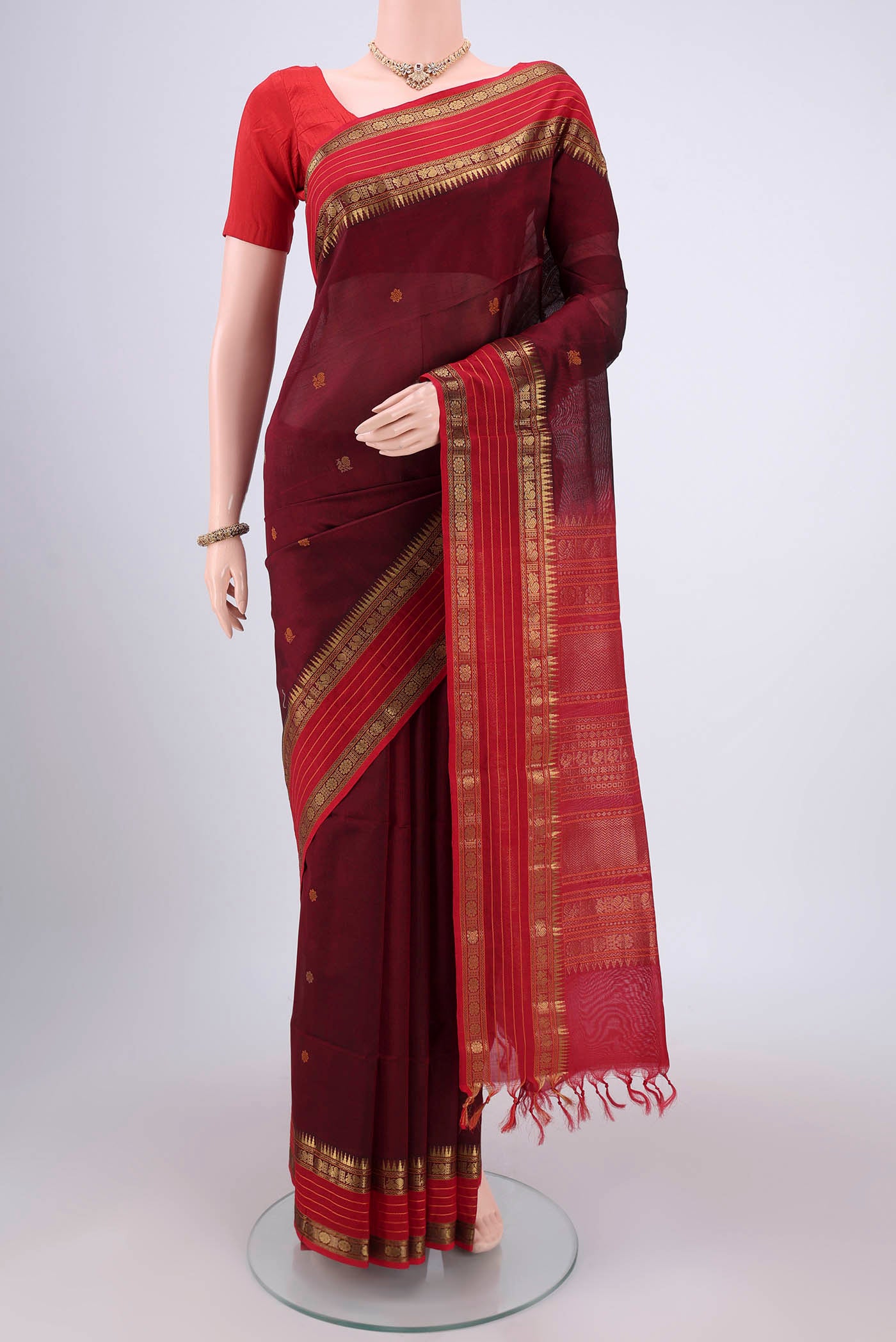 Maroon Coimbatore Silk Cotton Saree with Zari Butta on the body and Plain Border.  displayed on a mannequin