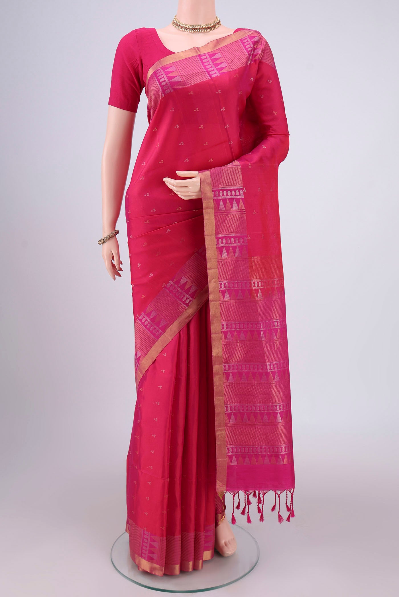 Rani Pink Soft Silk Saree with Zari Butta on the body and Zari Border.  displayed on a mannequin
