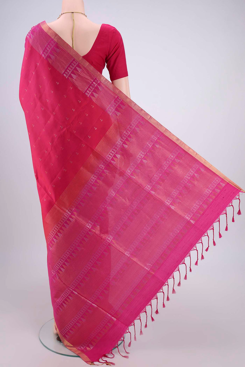Flat view of Rani Pink Soft Silk Saree with Zari Butta on the body and Zari Border. 