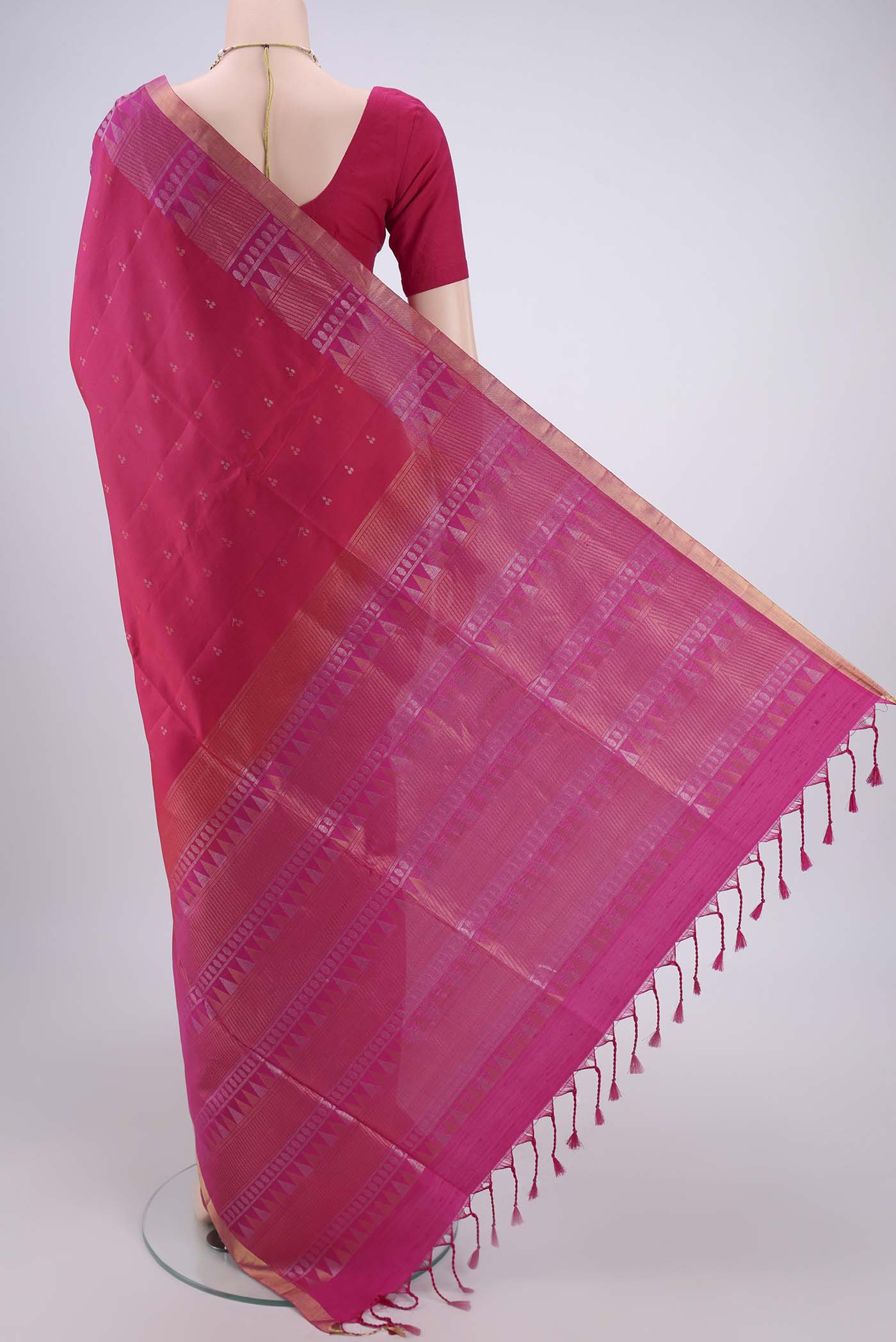 Flat view of Rani Pink Soft Silk Saree with Zari Butta on the body and Zari Border. 