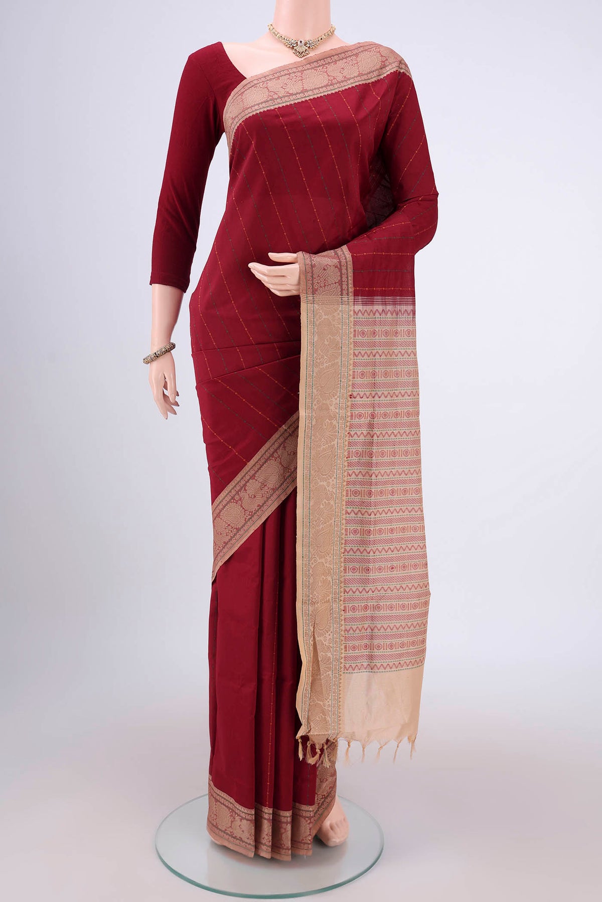 Maroon Blended Poly Cotton Saree with Stripes on the body and Thread Border.  displayed on a mannequin