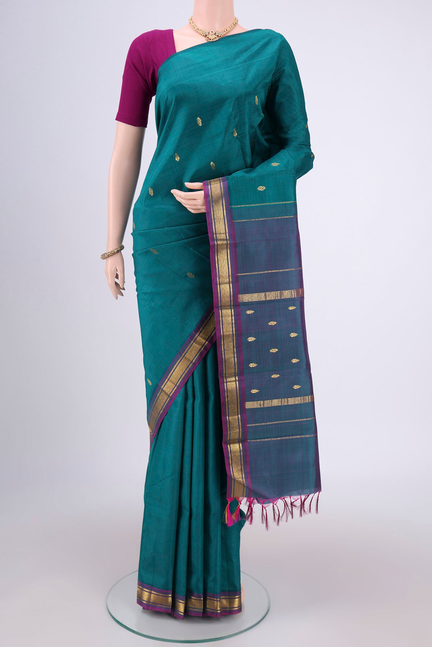Peacock Blue Kanchipuram Silk Saree with Zari Butta on the body and One Side Border.  displayed on a mannequin