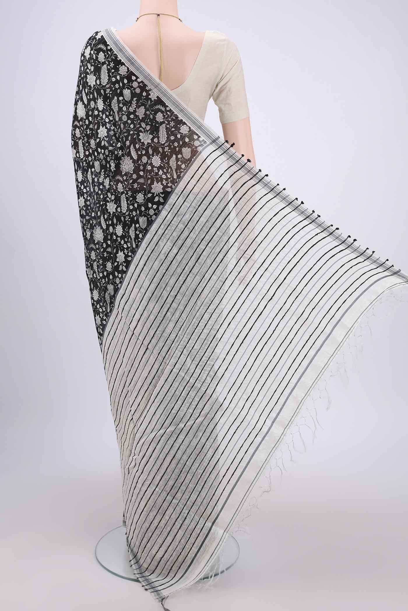 Flat view of Black Tussar Silk Saree with Printed design on the body and Plain Border. 