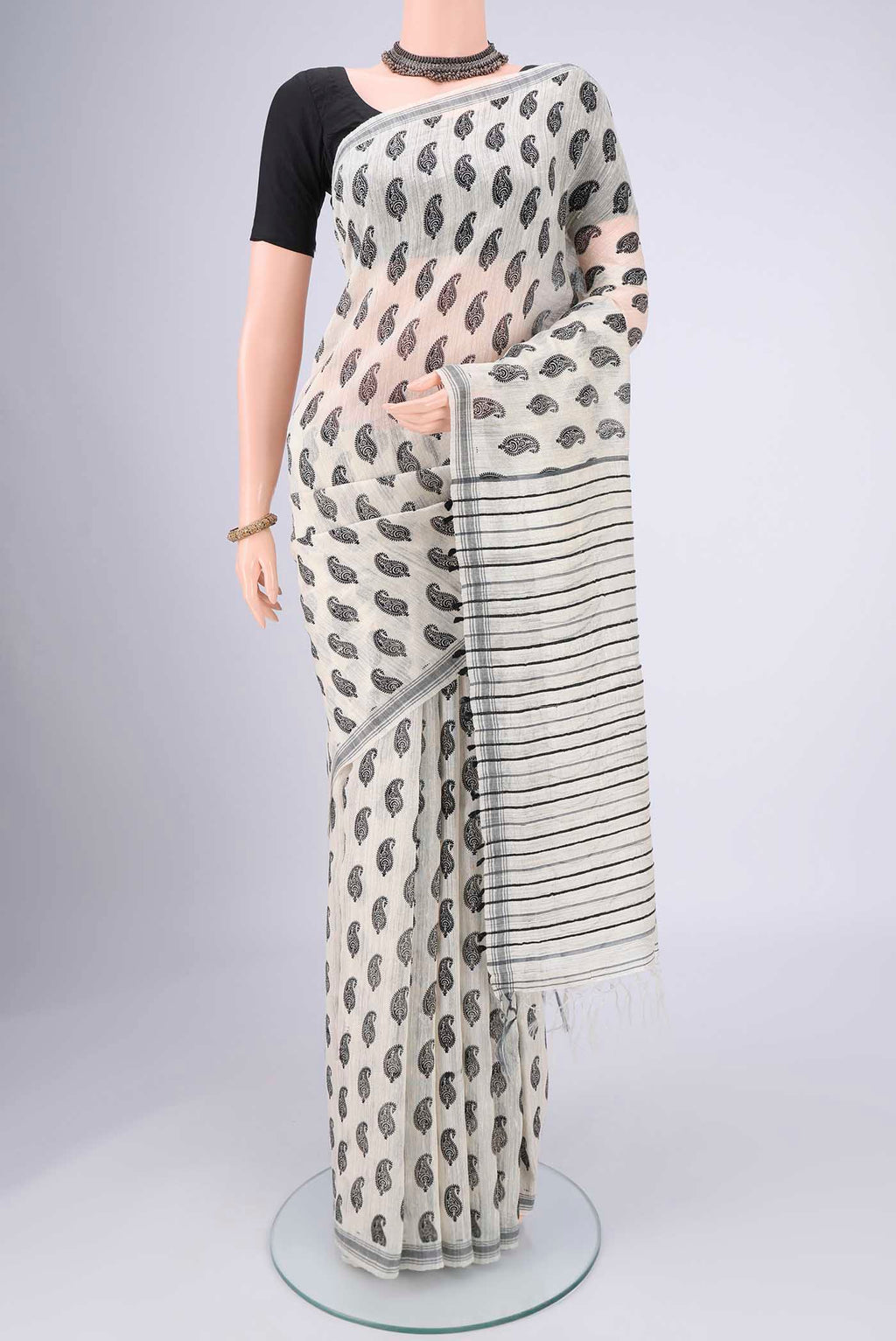 Off White Tussar Silk Saree with Printed design on the body and Plain Border.  displayed on a mannequin