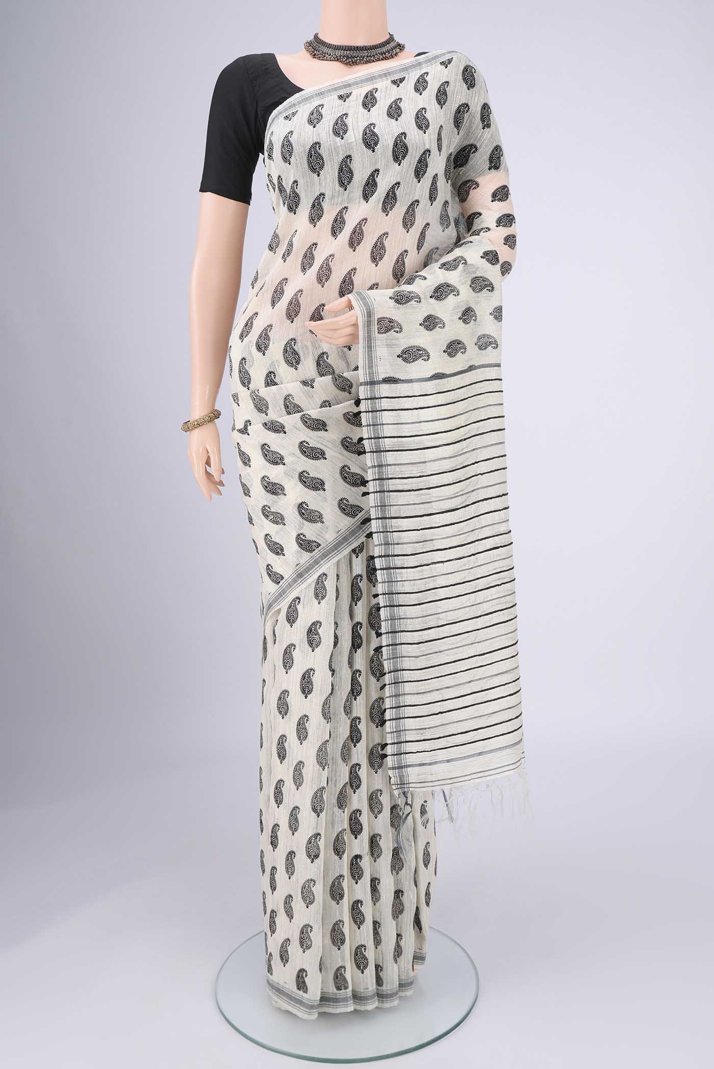 Off White Tussar Silk Saree with Printed design on the body and Plain Border.  displayed on a mannequin