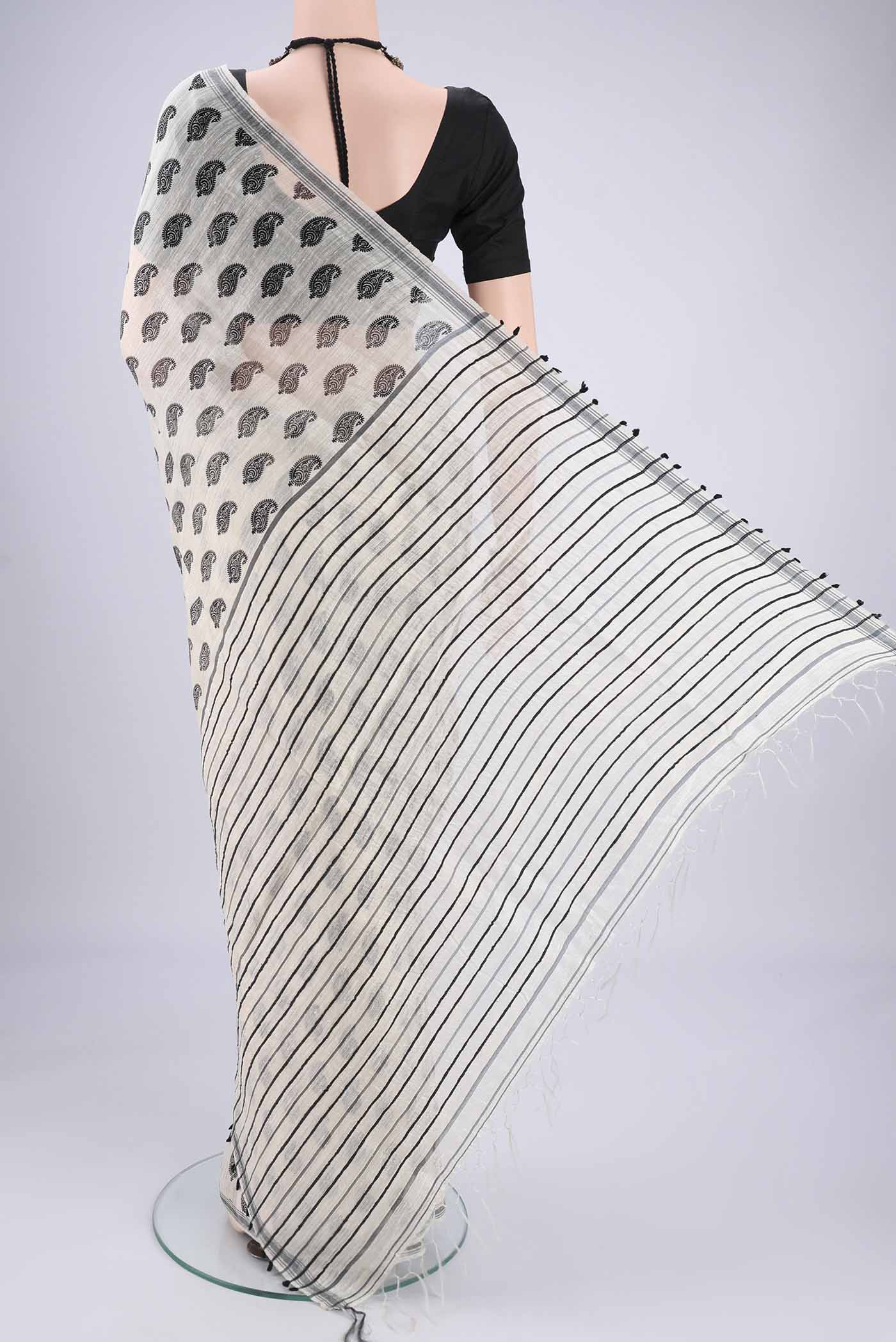 Flat view of Off White Tussar Silk Saree with Printed design on the body and Plain Border. 
