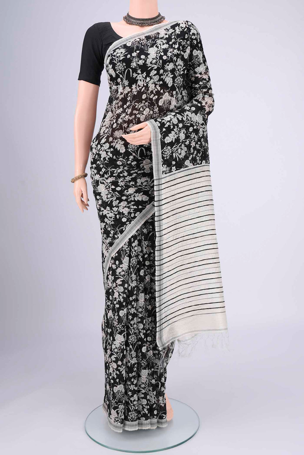 Black Tussar Silk Saree with Printed design on the body and Plain Border.  displayed on a mannequin