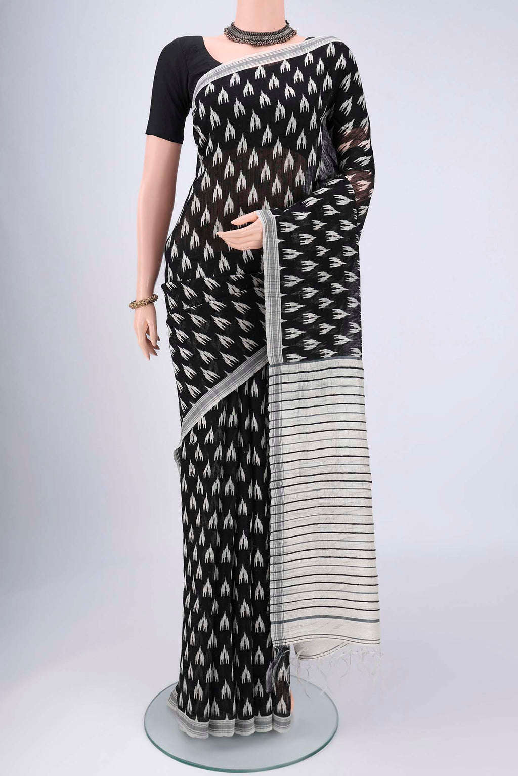 Black Tussar Silk Saree with Printed design on the body and Plain Border.  displayed on a mannequin