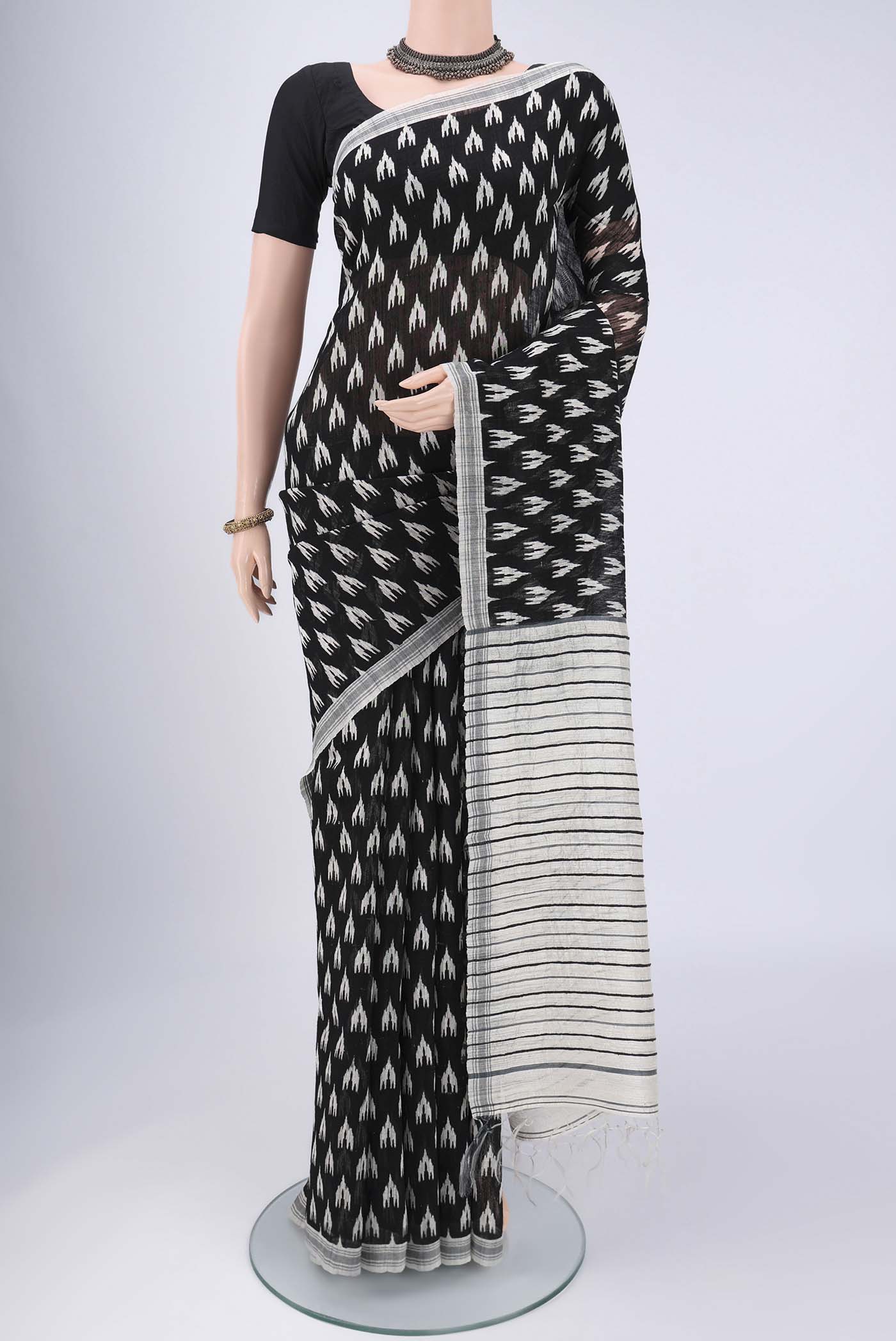 Black Tussar Silk Saree with Printed design on the body and Plain Border.  displayed on a mannequin