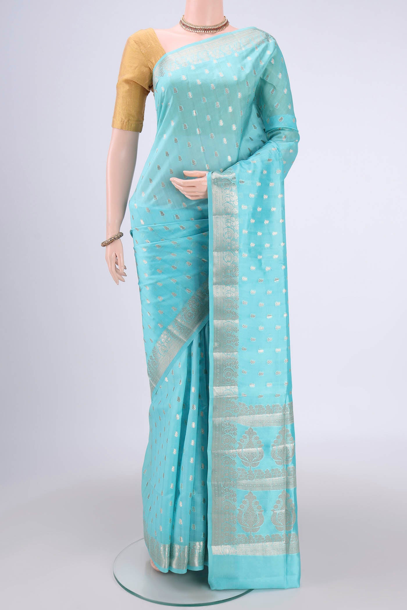 Turquoise Banarasi Raw Silk Saree with Zari Butta on the body and Zari Border.  displayed on a mannequin