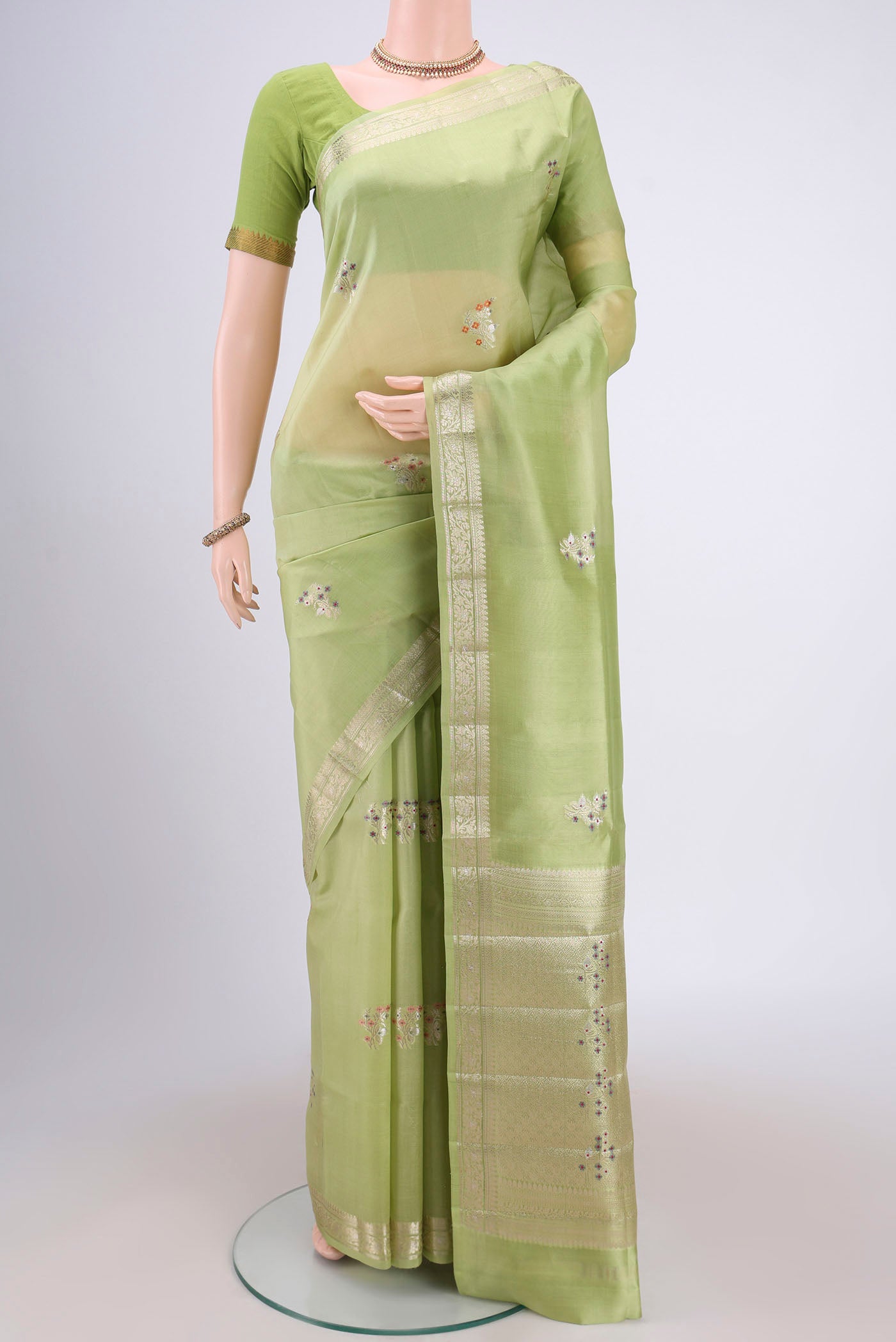 Light Green Banarasi Raw Silk Saree with Zari And Thread Butta on the body and Zari Border.  displayed on a mannequin