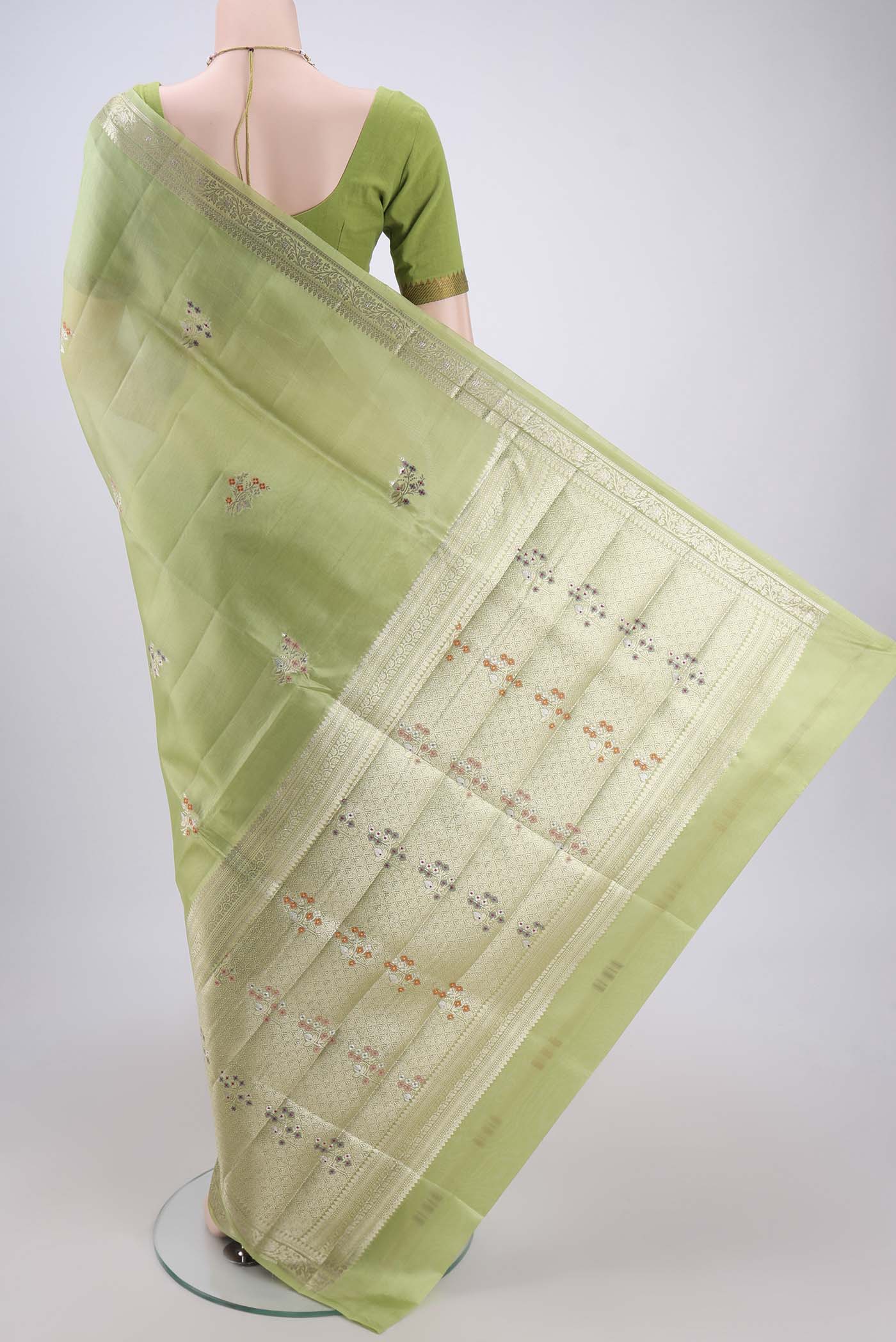 Flat view of Light Green Banarasi Raw Silk Saree with Zari And Thread Butta on the body and Zari Border. 