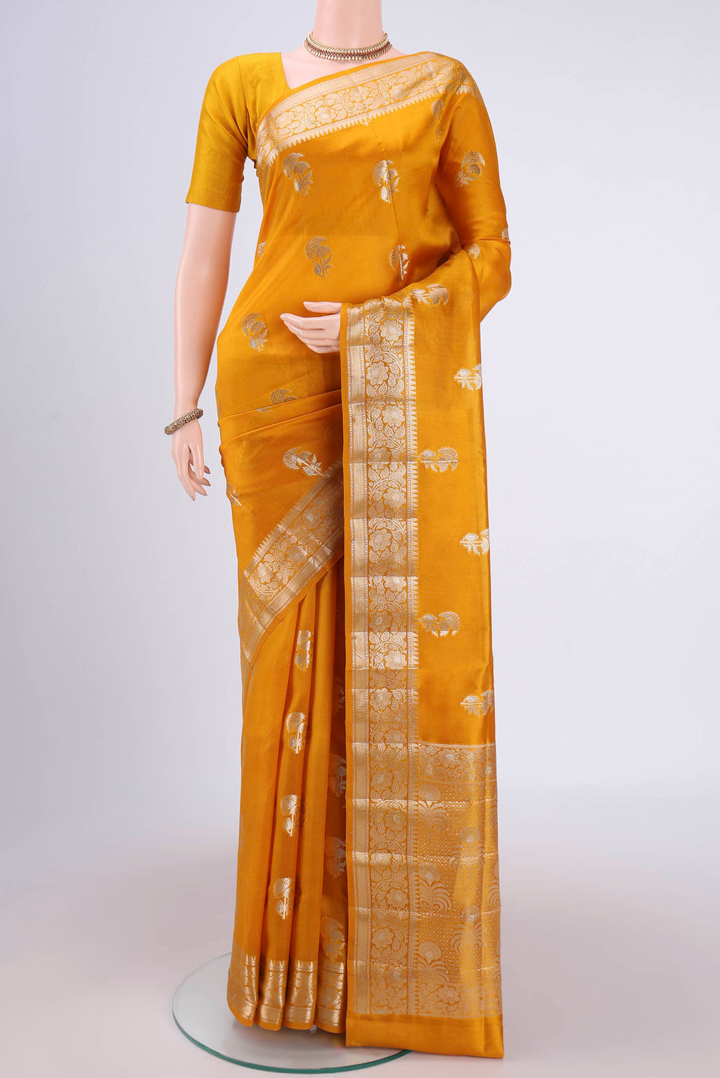 Yellow Banarasi Raw Silk Saree with Zari Butta on the body and Zari Border.  displayed on a mannequin