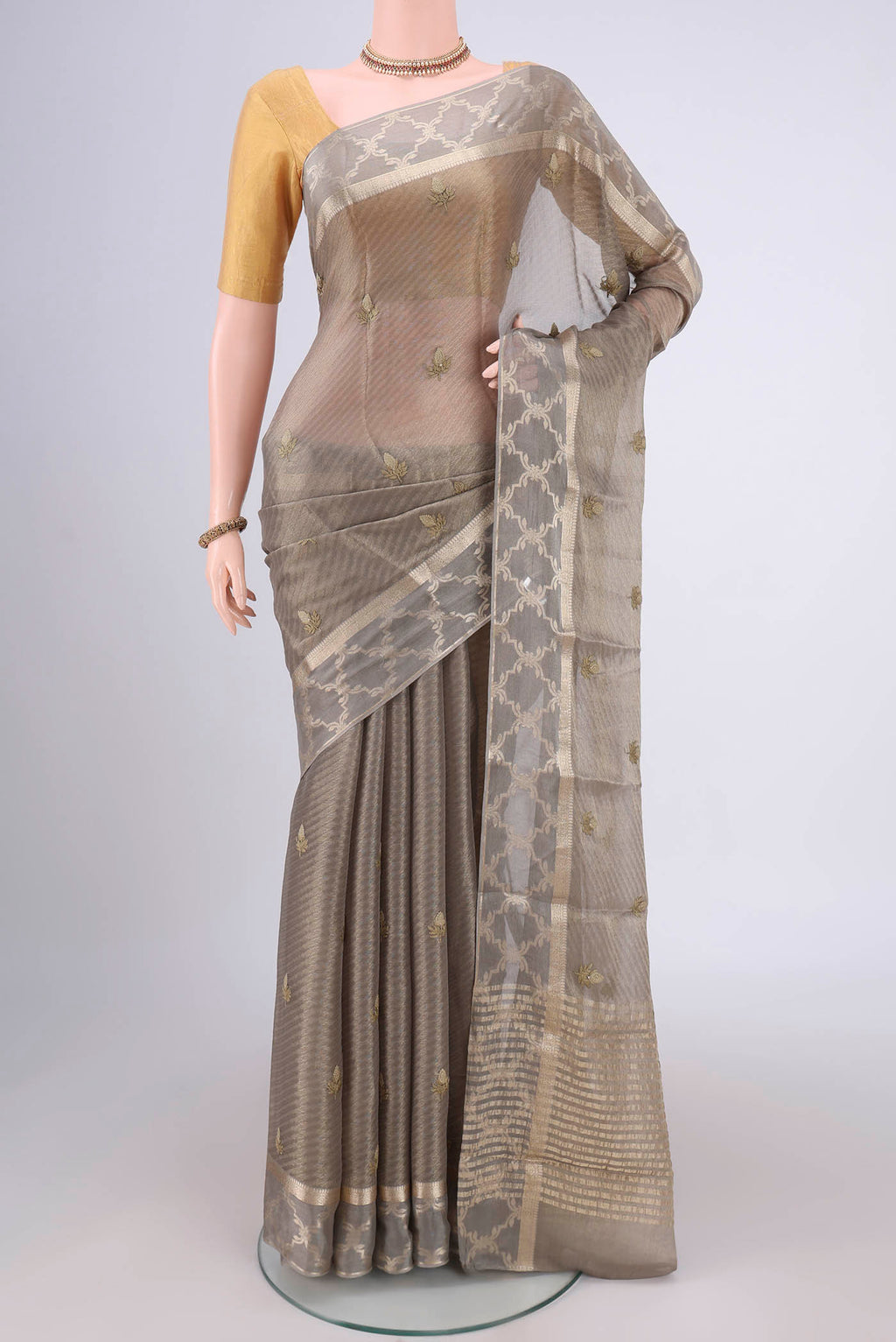 Davys Grey Mysore Georgette Saree with Embroidery on the body and Zari Border.  displayed on a mannequin