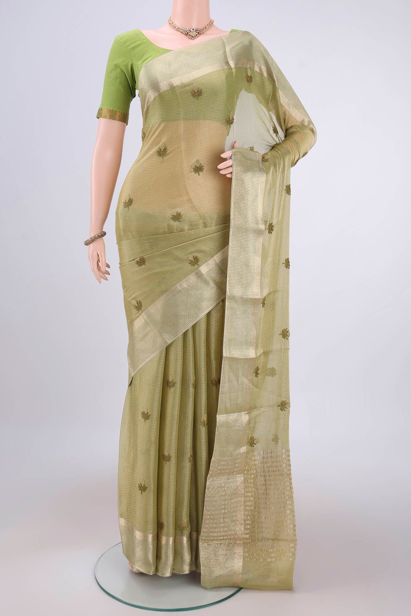 Pista Green Mysore Georgette Saree with Embroidery on the body and Zari Border.  displayed on a mannequin
