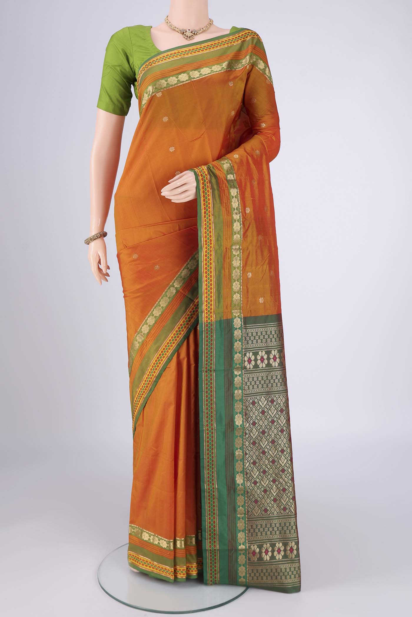 Brick Orange Blended Bangalore Silk Saree with Jacquard design on the body and Zari Border.  displayed on a mannequin