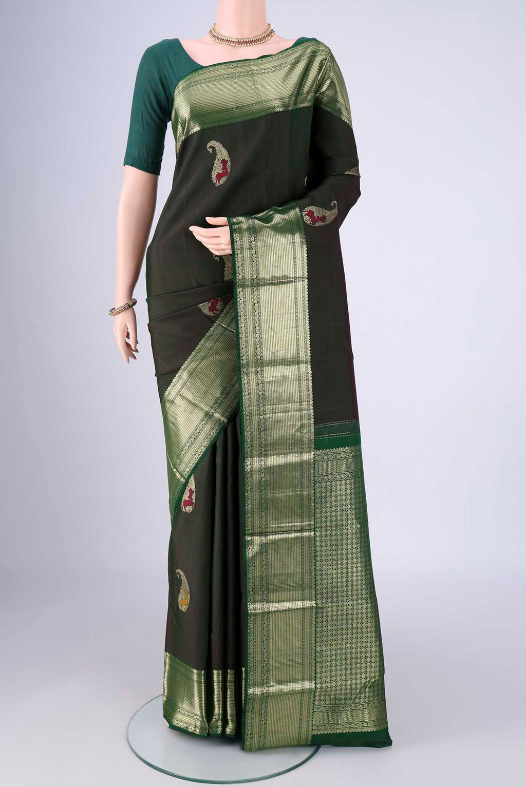 Bottle Green Kanjivaram Silk Saree with Zari Butta on the body and Zari Border.  displayed on a mannequin