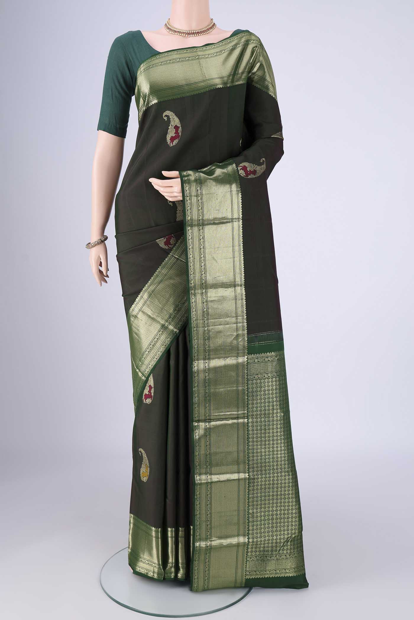 Bottle Green Kanjivaram Silk Saree with Zari Butta on the body and Zari Border.  displayed on a mannequin