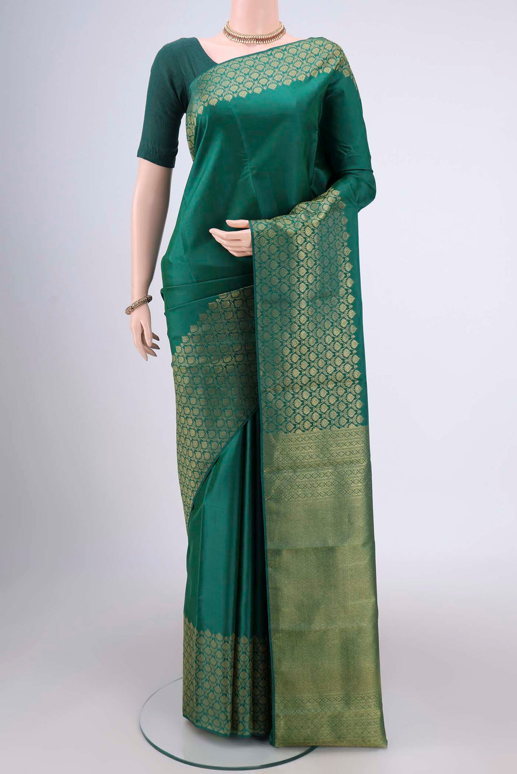 Bottle Green Kanjivaram Silk Saree with Plain Body and Zari Border.  displayed on a mannequin