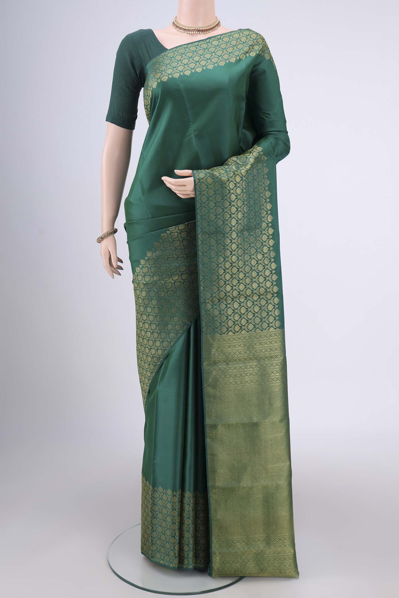 Bottle Green Kanjivaram Silk Saree with Plain Body and Zari Border.  displayed on a mannequin